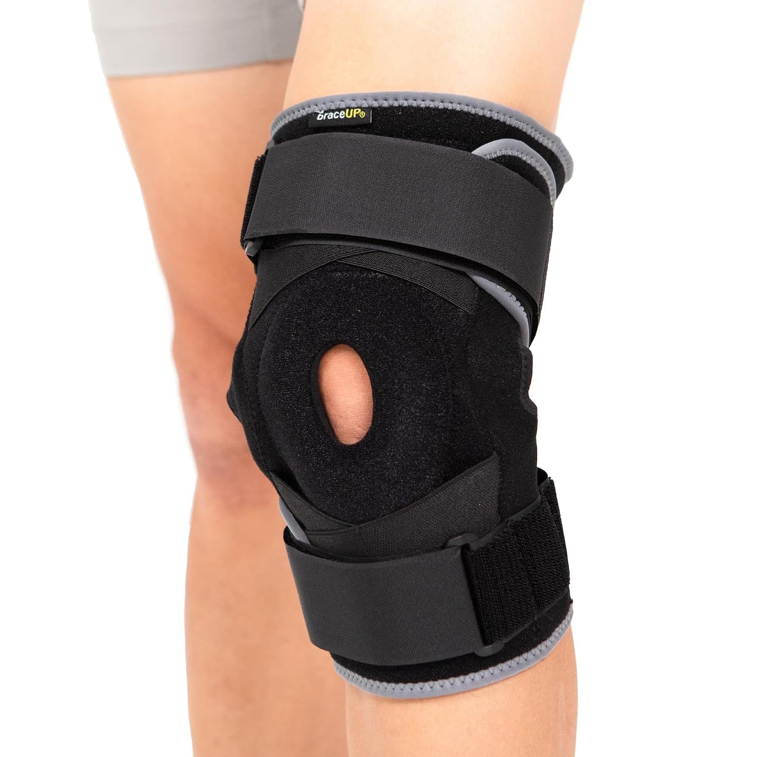 Schwarze Kniebandage mit seitlichen Federn, Patella-Öffnung und Klettverschluss-Riemen.