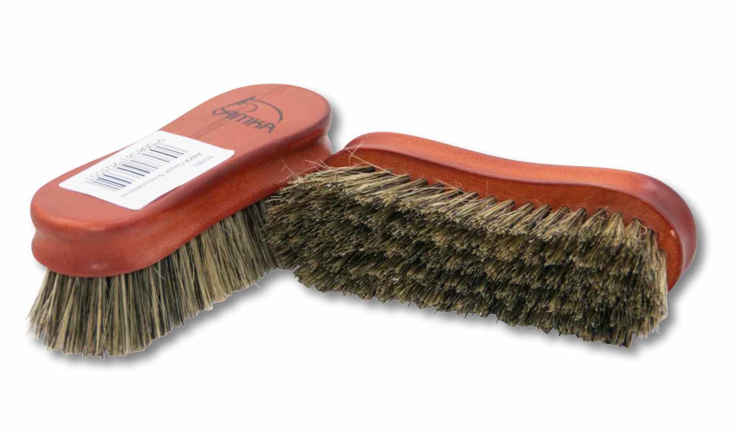 Zwei AMKA Classic Schmusebürsten. Die Bürsten haben einen Holzrücken und Borsten. Auf einer Bürste ist ein Etikett mit Barcode angebracht. Die Bürsten sind für die Fellpflege von Pferden gedacht.
