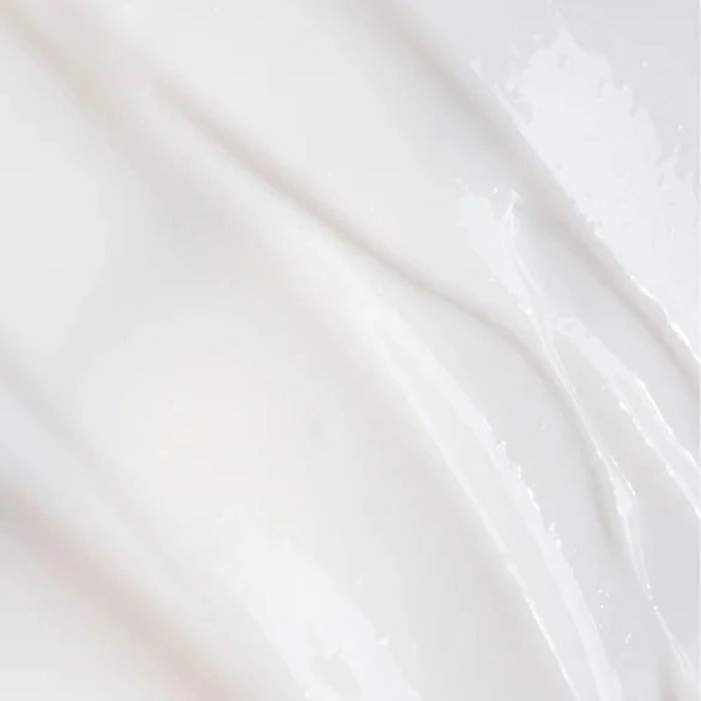 Nahaufnahme einer weißen Creme. Glatte, glänzende Textur. Leichte Wellen.