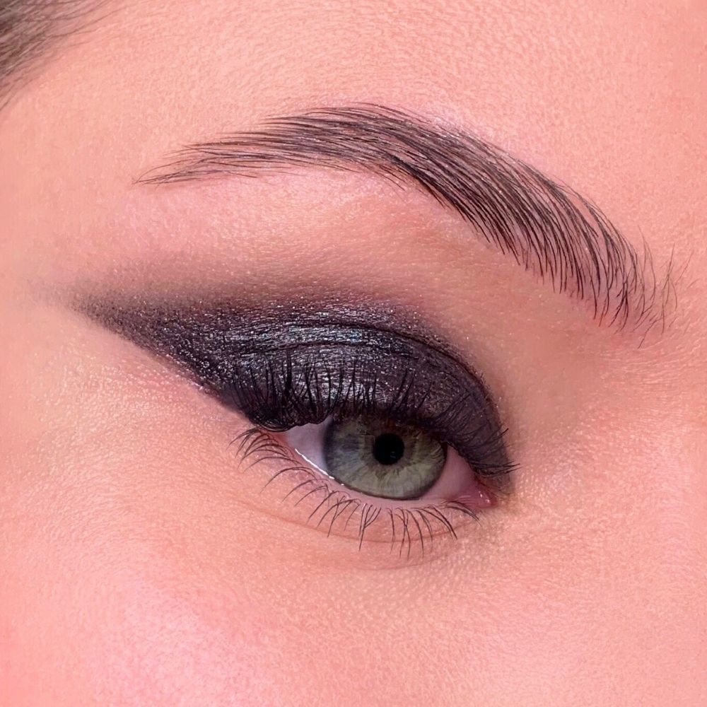 Auge mit schwarzem Lidschatten. Dunkler, intensiver Lidschatten. Augenlid, Wimpern, Augenbraue.