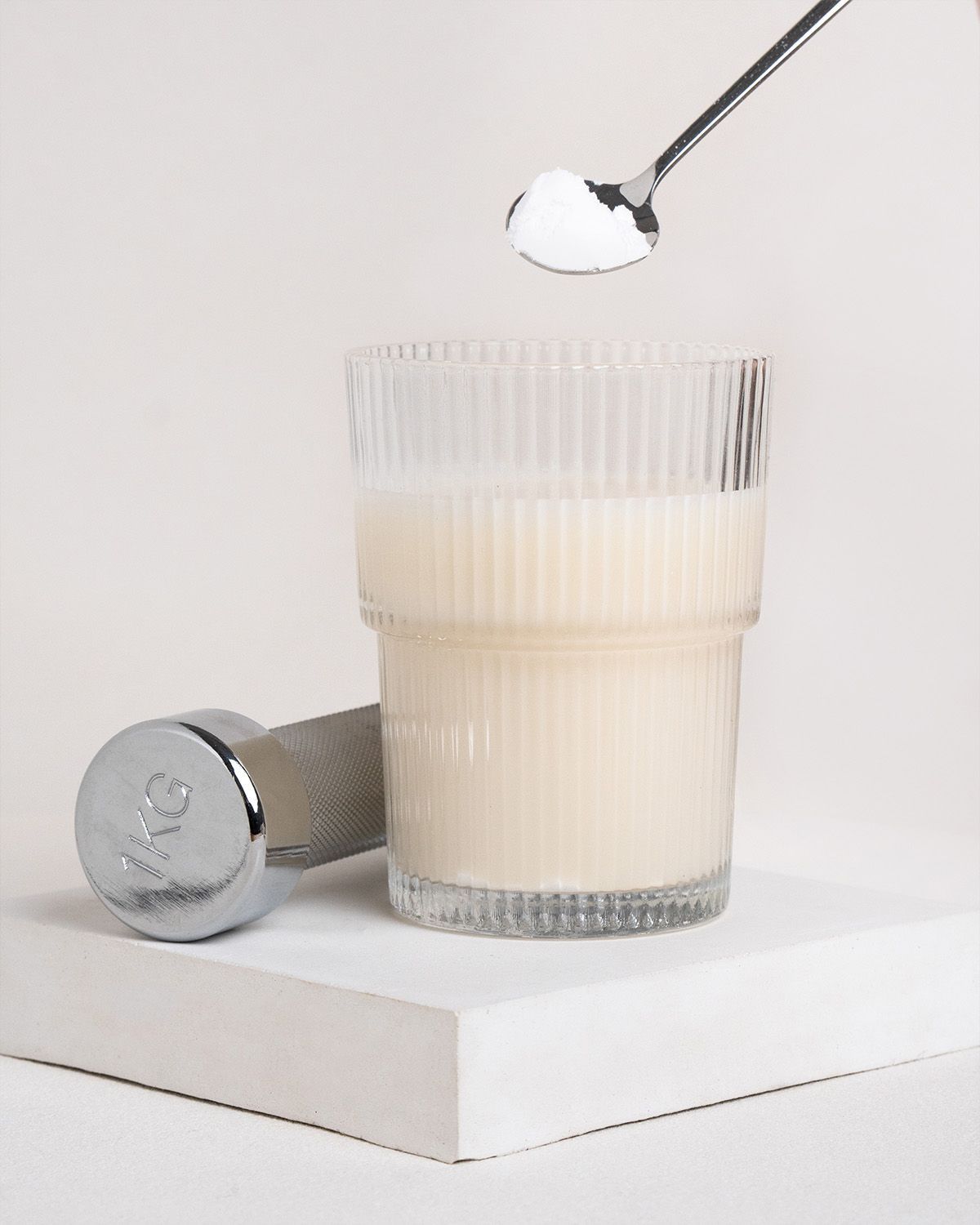 Glas mit Flüssigkeit, Löffel mit Pulver und Kurzhantel. Flüssigkeit und Pulver sind weiß.