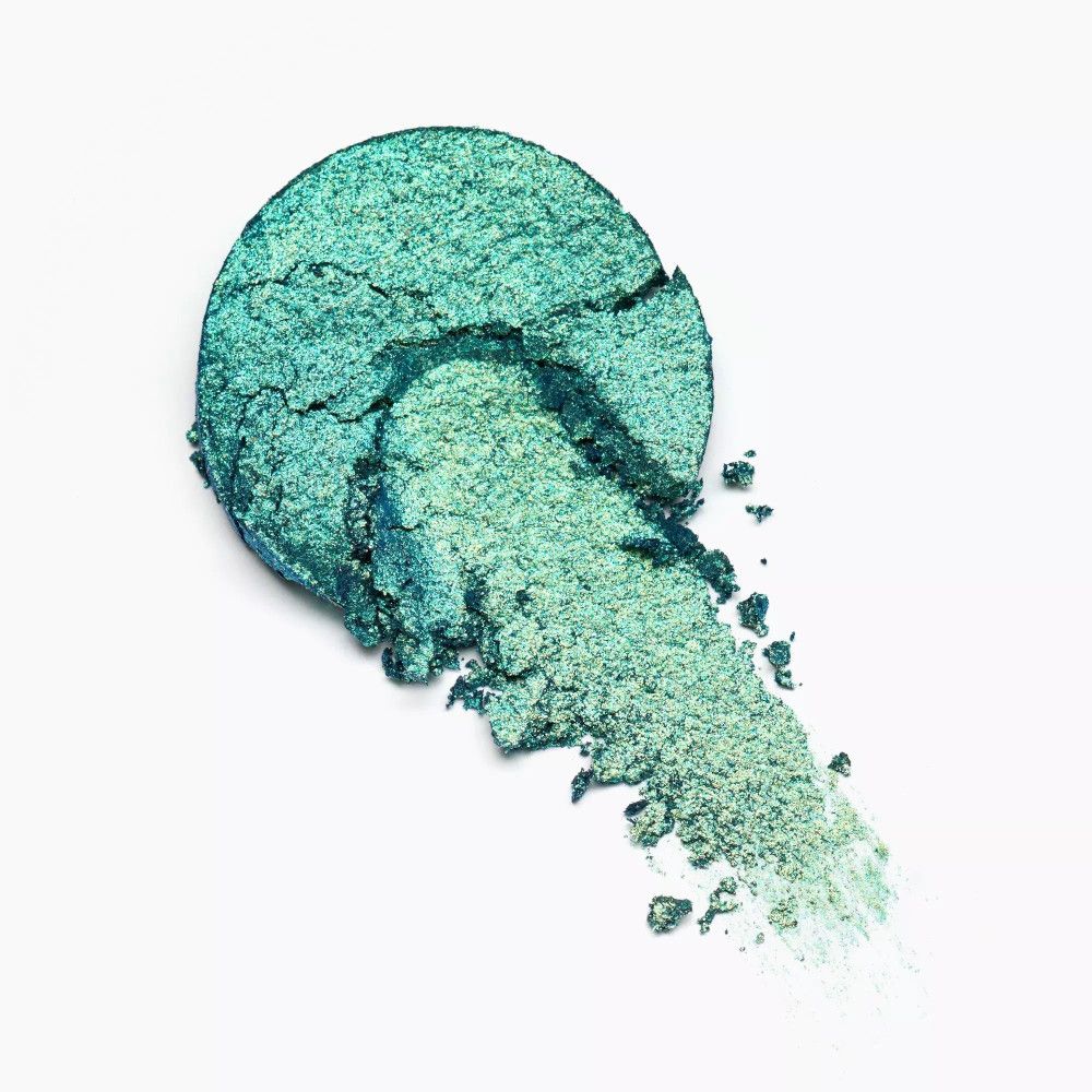 Abgebrochener, grüner Lidschatten-Swatch. Schimmernde Textur. Auf weißem Hintergrund.