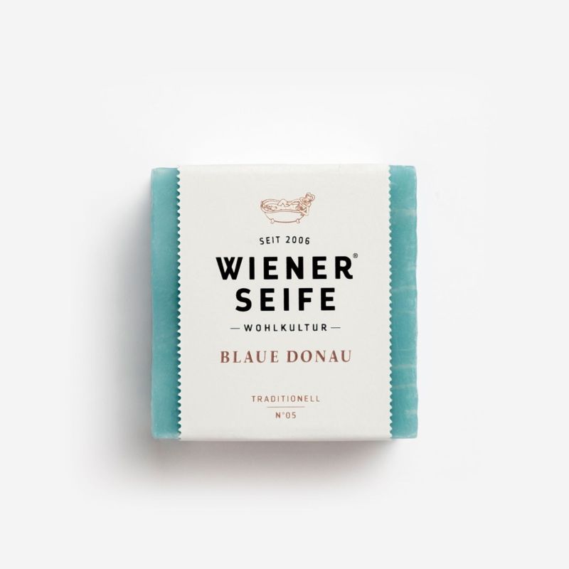 Quadratische Seife, blau, mit Papierbanderole. Aufschrift: Wiener Seife, Blaue Donau, Traditionell N°05.