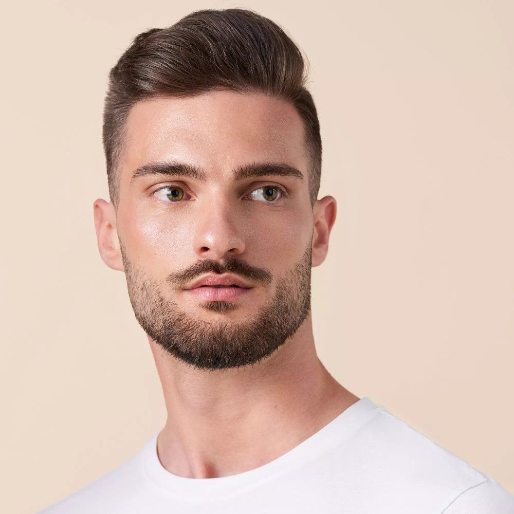 Porträt eines Mannes mit Bart. Hautton und Make-up sichtbar.