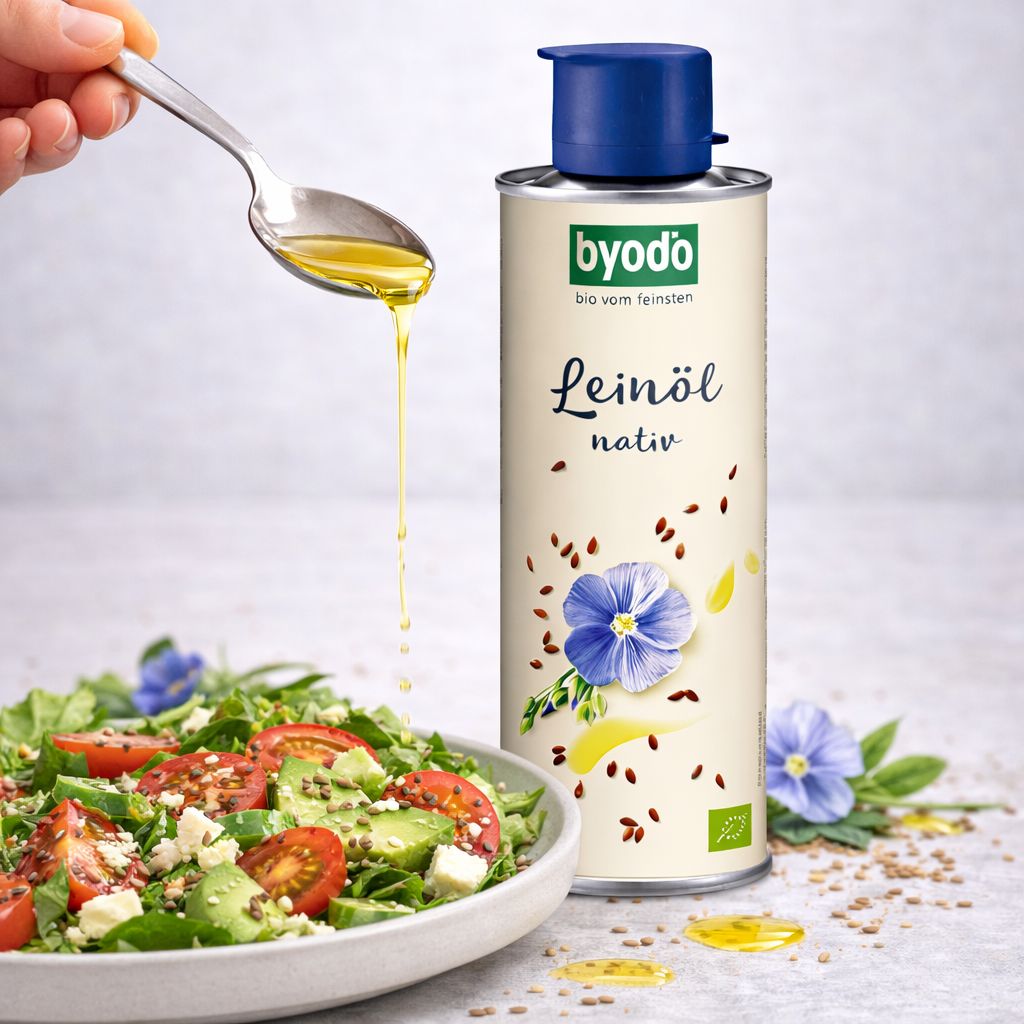 Byodo Bio Leinöl nativ in einer Dose mit blauem Verschluss, daneben ein Salat mit Avocado und Tomaten.