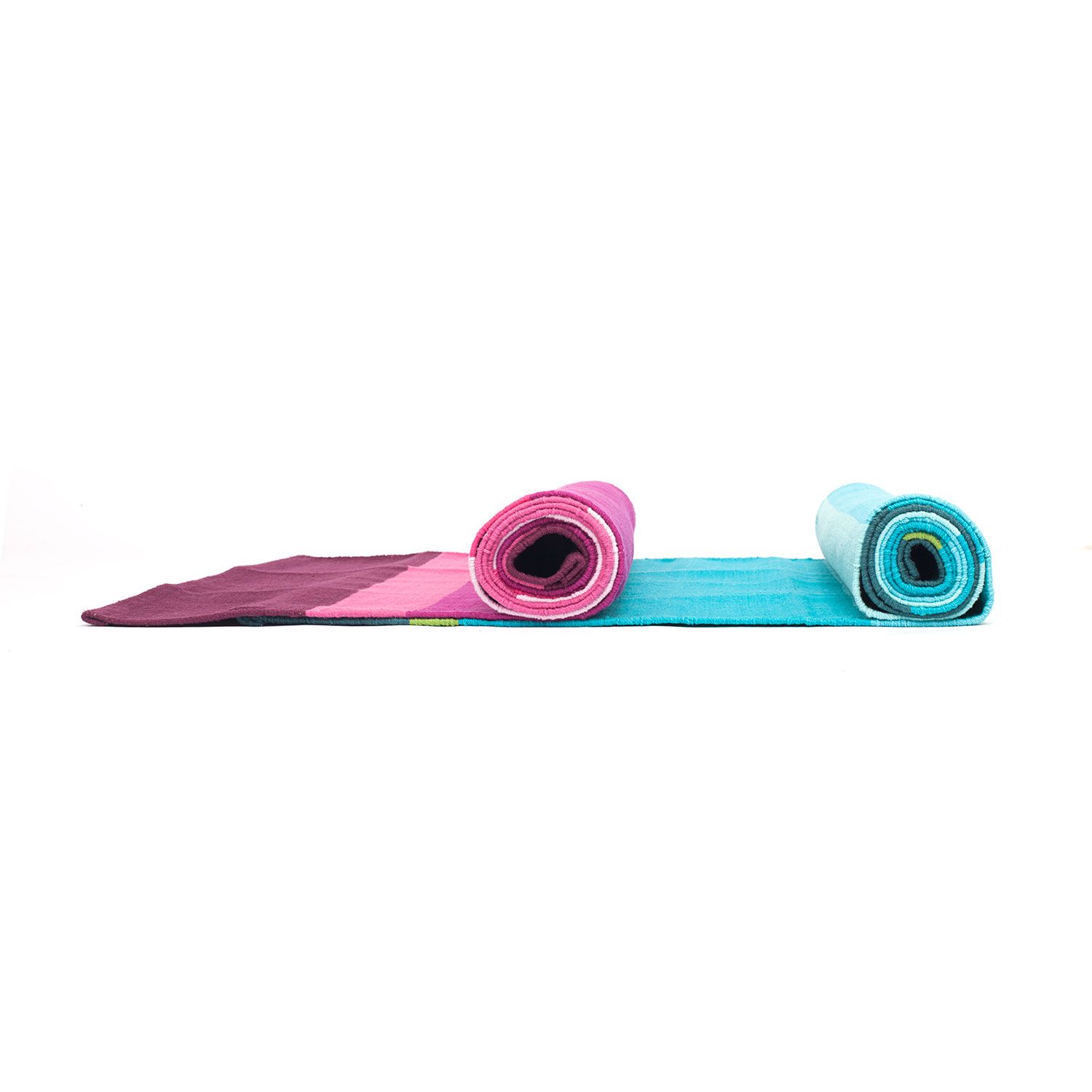 Zwei gerollte Yoga-Matten. Eine in Petrol, Türkis, Grün, die andere in Rosa und Pink. Streifenmuster sichtbar.