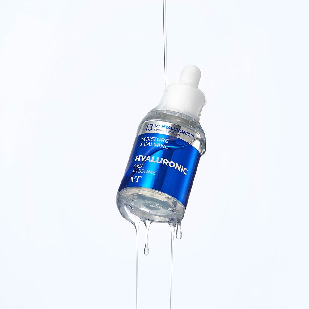 Klarflüssiges Serum in einer Flasche mit blauem Etikett. Tropfen fallen. Text: Hyaluronic Cica Exosome, VT.