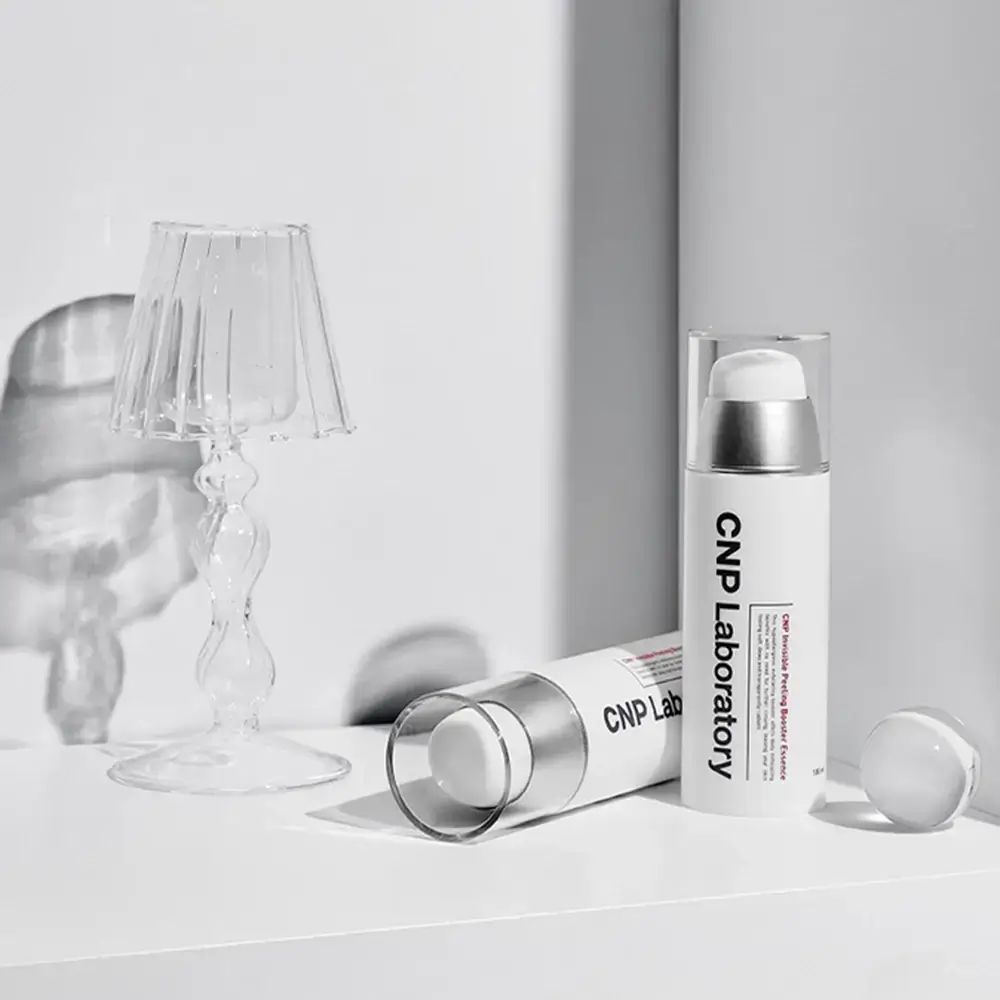 Zwei weiße Flaschen mit silbernen Pumpköpfen. Aufschrift: CNP Laboratory. Eine Flasche liegt.