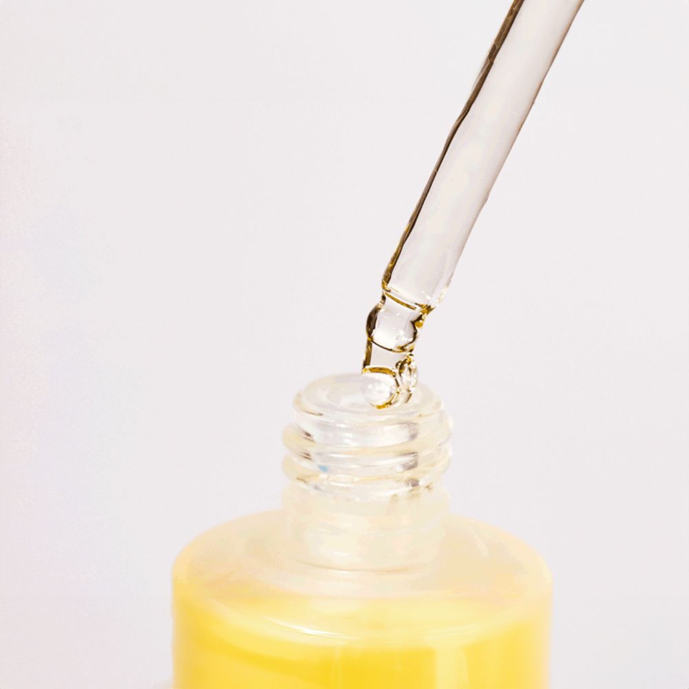 Nahaufnahme einer Pipette, die Flüssigkeit in eine Flasche ANUA Heartleaf 80% Soothing Ampoule tropft.