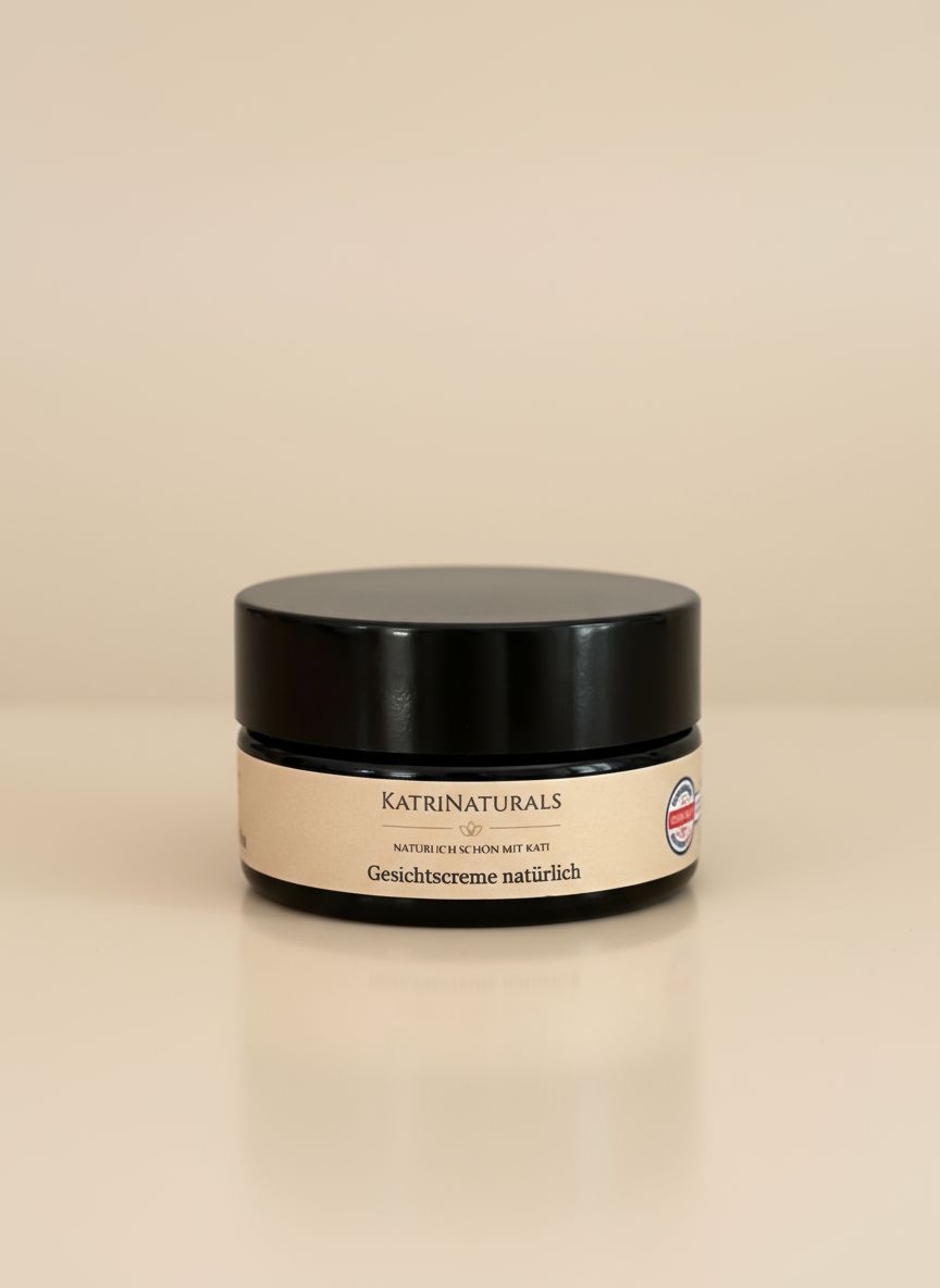 Creme-Tiegel mit schwarzem Deckel und beigem Etikett. Aufschrift: KatriNaturals, Gesichtscreme natürlich. Siegel.