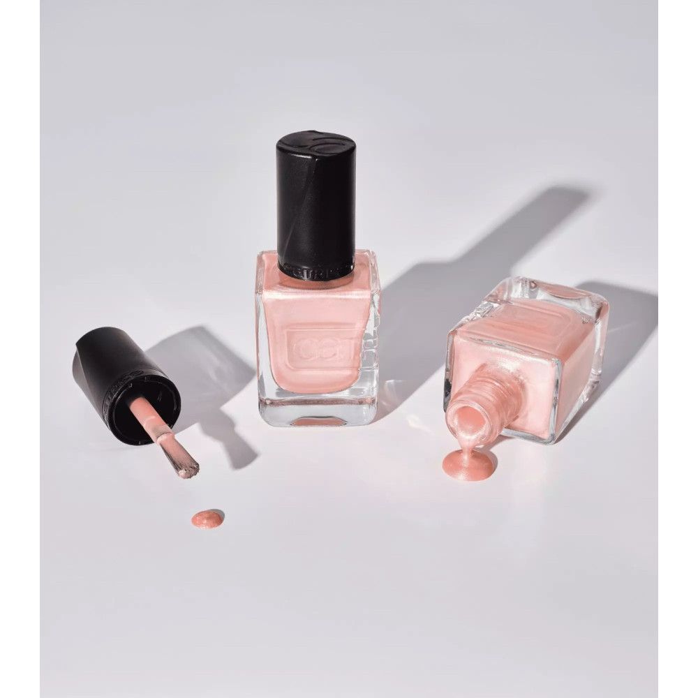 Nagellackflaschen, eine mit Pinsel, eine umgekippt. Der Nagellack ist rosa. Der Markenname Catrice ist sichtbar.