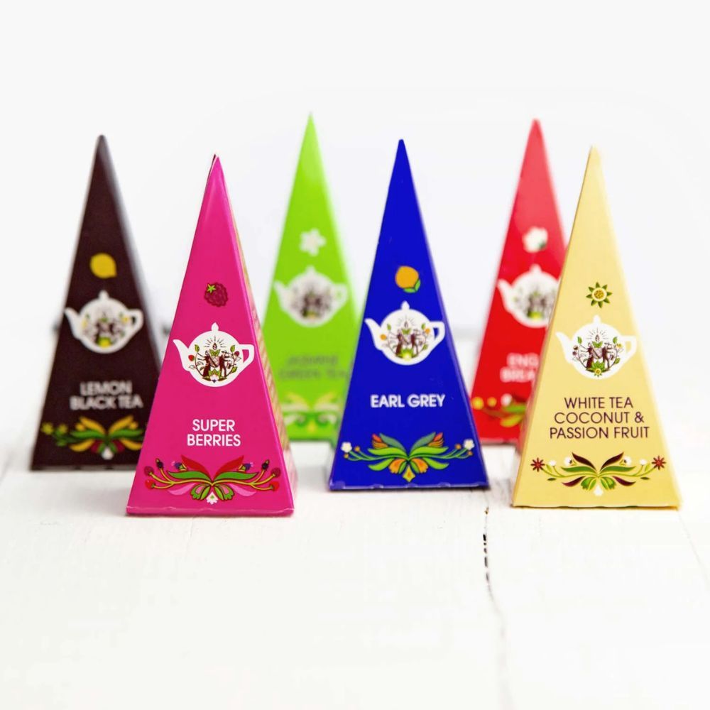 Sechs farbige Pyramidenboxen mit Tee. Aufschriften: Lemon Black Tea, Super Berries, Earl Grey, White Tea Coconut & Passion Fruit.