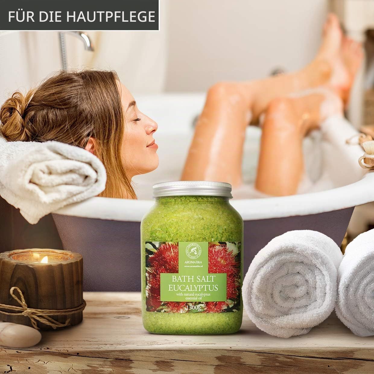 Aromatica Bade-Salz Eukalyptus: Großes Glas mit grünem Badesalz und roter Blüten-Dekoration in einem Badezimmer.