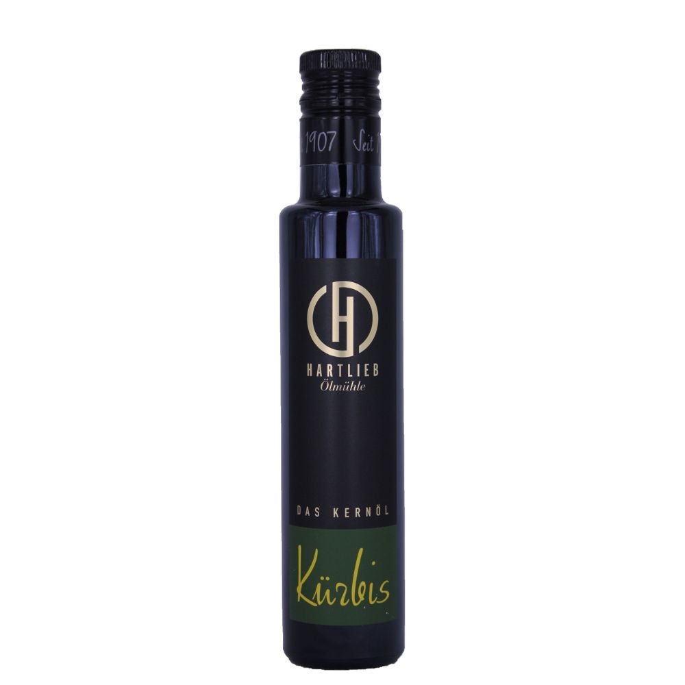 Schwarze Glasflasche mit Hartlieb Kürbiskernöl-Etikett. Grünes Etikett mit Kürbis-Schriftzug. Schwarzer Schraubverschluss.
