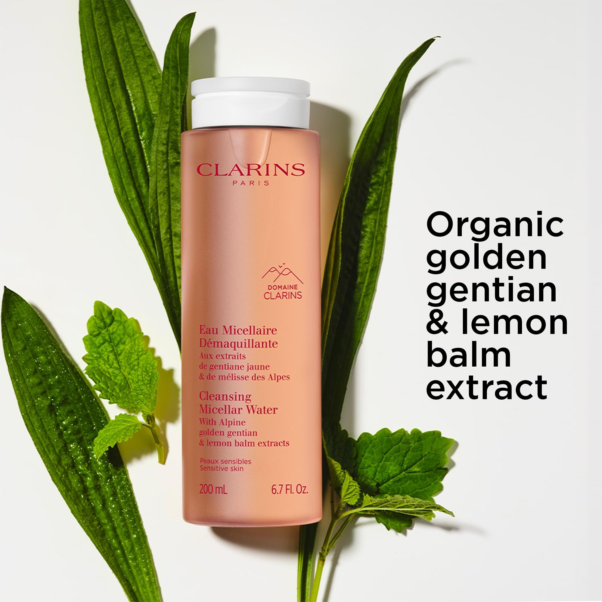 Rosa Flasche mit Blättern. Text: Clarins, Eau Micellaire Démaquillante. Mit goldenem Enzian und Zitronenmelisse-Extrakt.