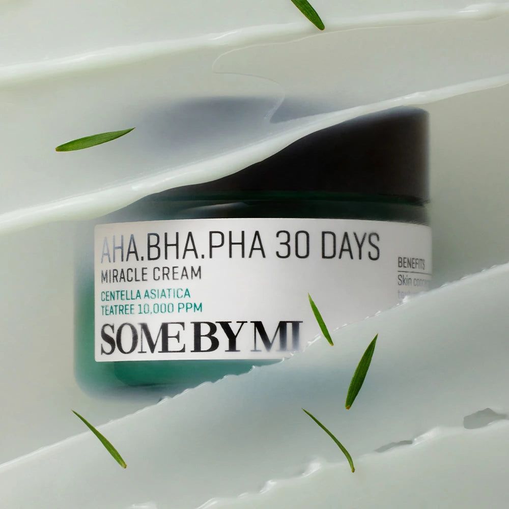 Grüner Tiegel mit AHA-BHA-PHA 30 Tage Miracle Cream von SOMEBYMI, umgeben von weißen Streifen und grünen Blättern.