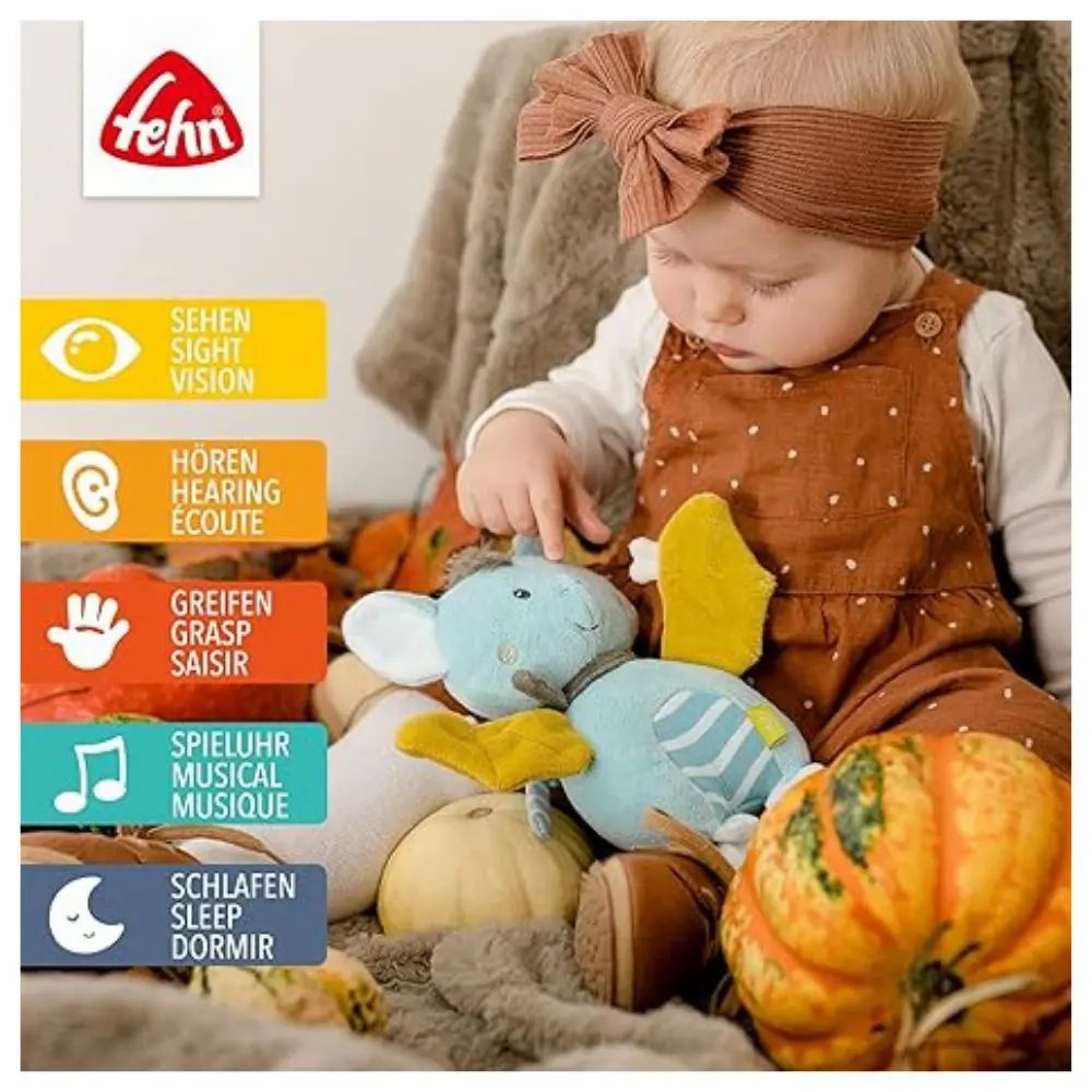 Baby mit Fledermaus-Spieluhr. Text: Sehen, Hören, Greifen, Spieluhr, Schlafen. Logo Fehn.