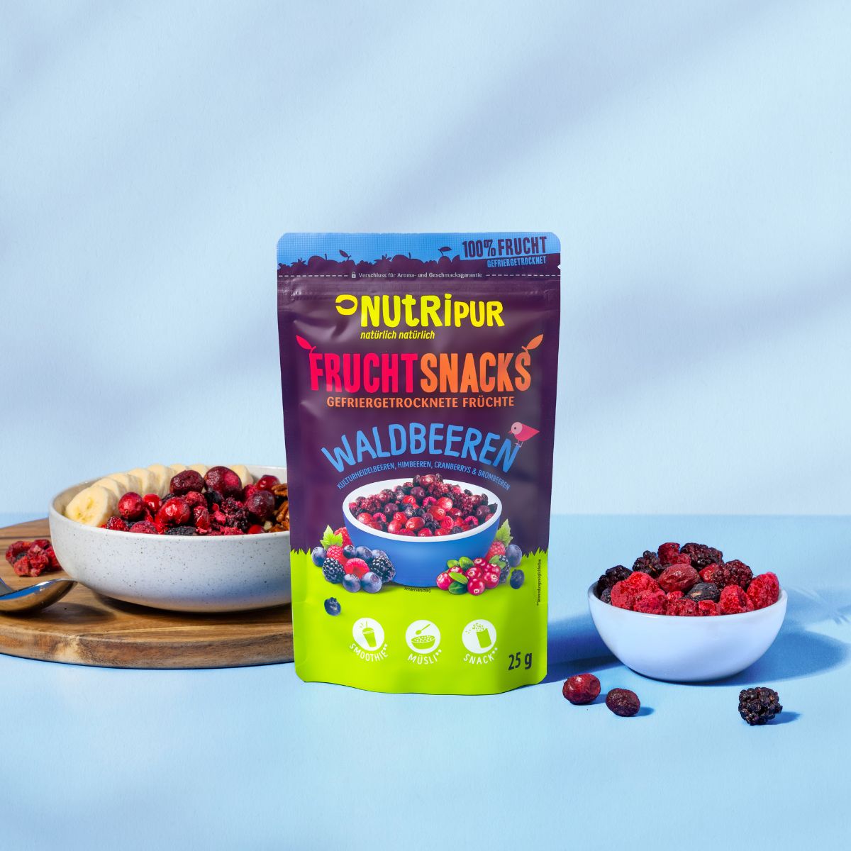 Packung NutriPur Waldbeeren und Schalen mit Beeren und Bananenscheiben. Aufschrift: Fruchtsnacks, 25g.