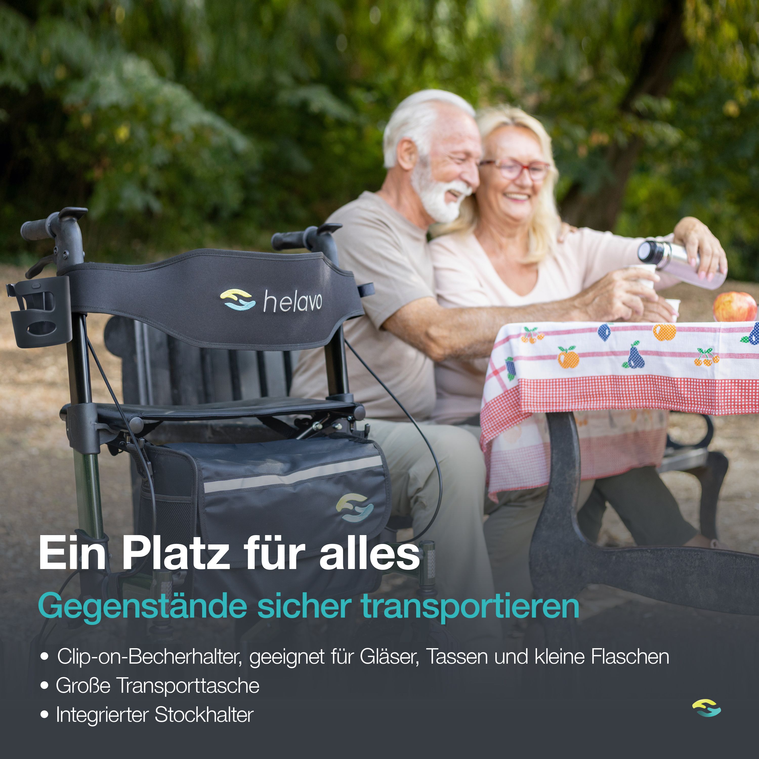 Grüner Rollator mit Sitz und Tasche neben einem Paar im Park. Becherhalter und Stockhalter sichtbar.