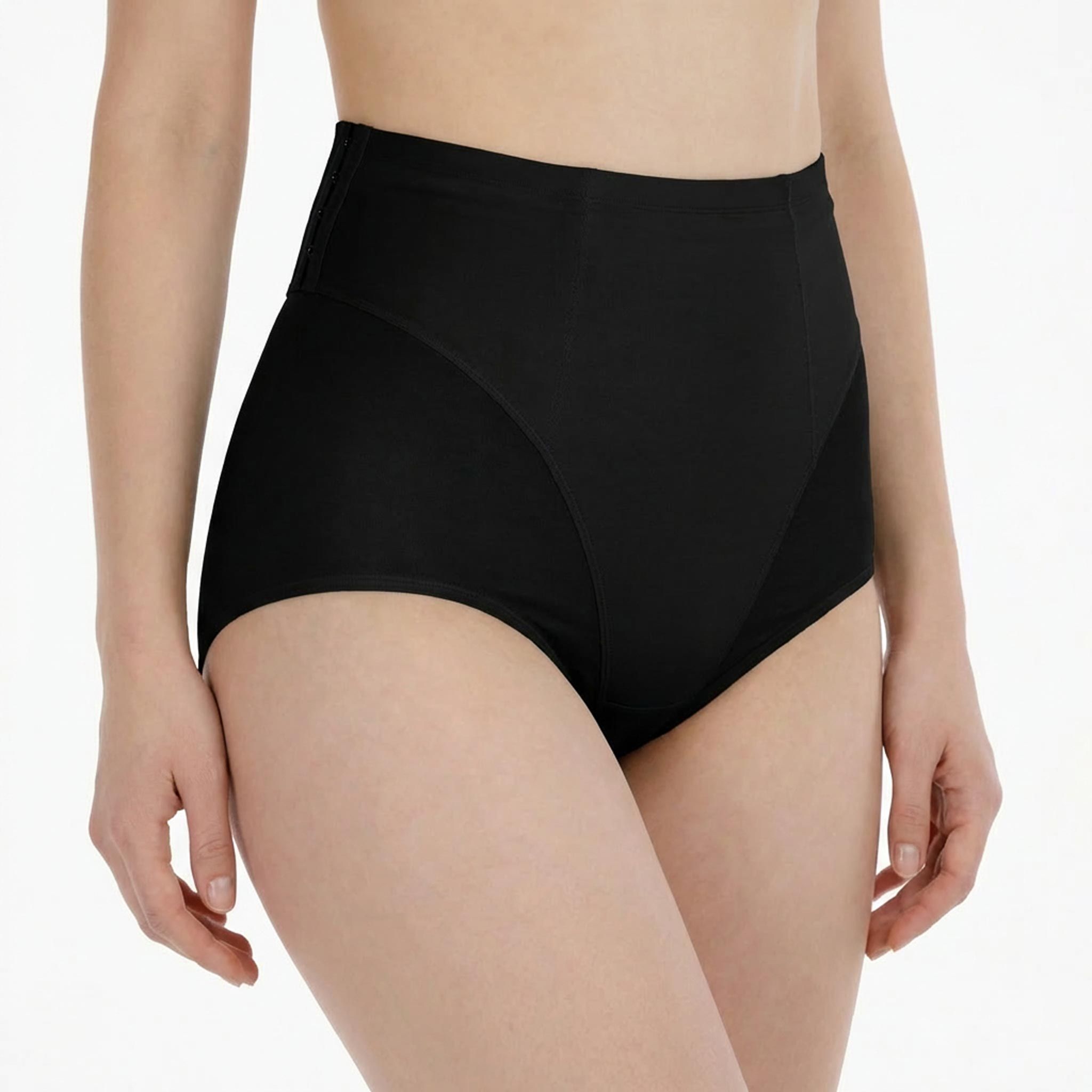 Schwarze Miederhose, hoher Bund, seitliche Einsätze. Angeschnittene Frau, von vorne, Hüfte und Bauchbereich.