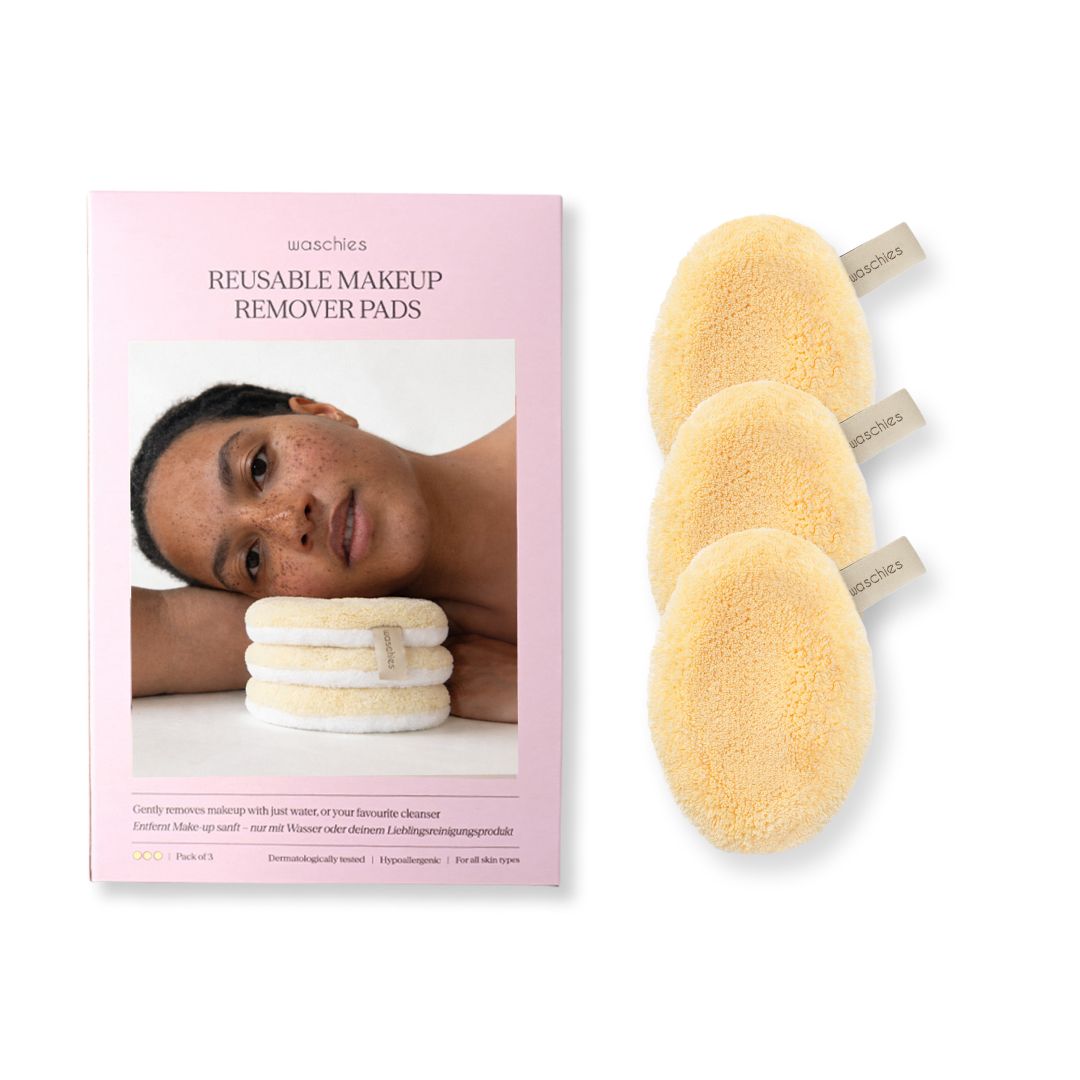 Verpackung mit drei gelben Abschminkpads. Aufdruck: REUSABLE MAKEUP REMOVER PADS. Frau liegt auf der Verpackung.
