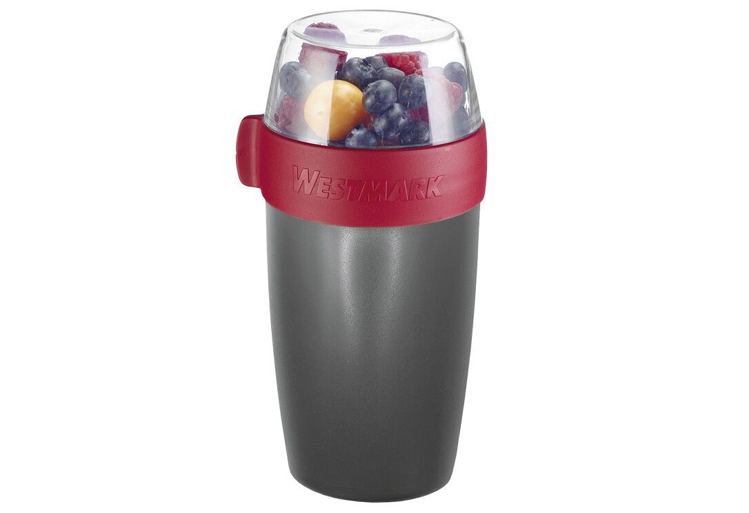 Dunkelgrauer Müslibecher mit rotem Band und transparentem Deckel. Enthält Früchte. WESTMARK-Logo auf dem Band.