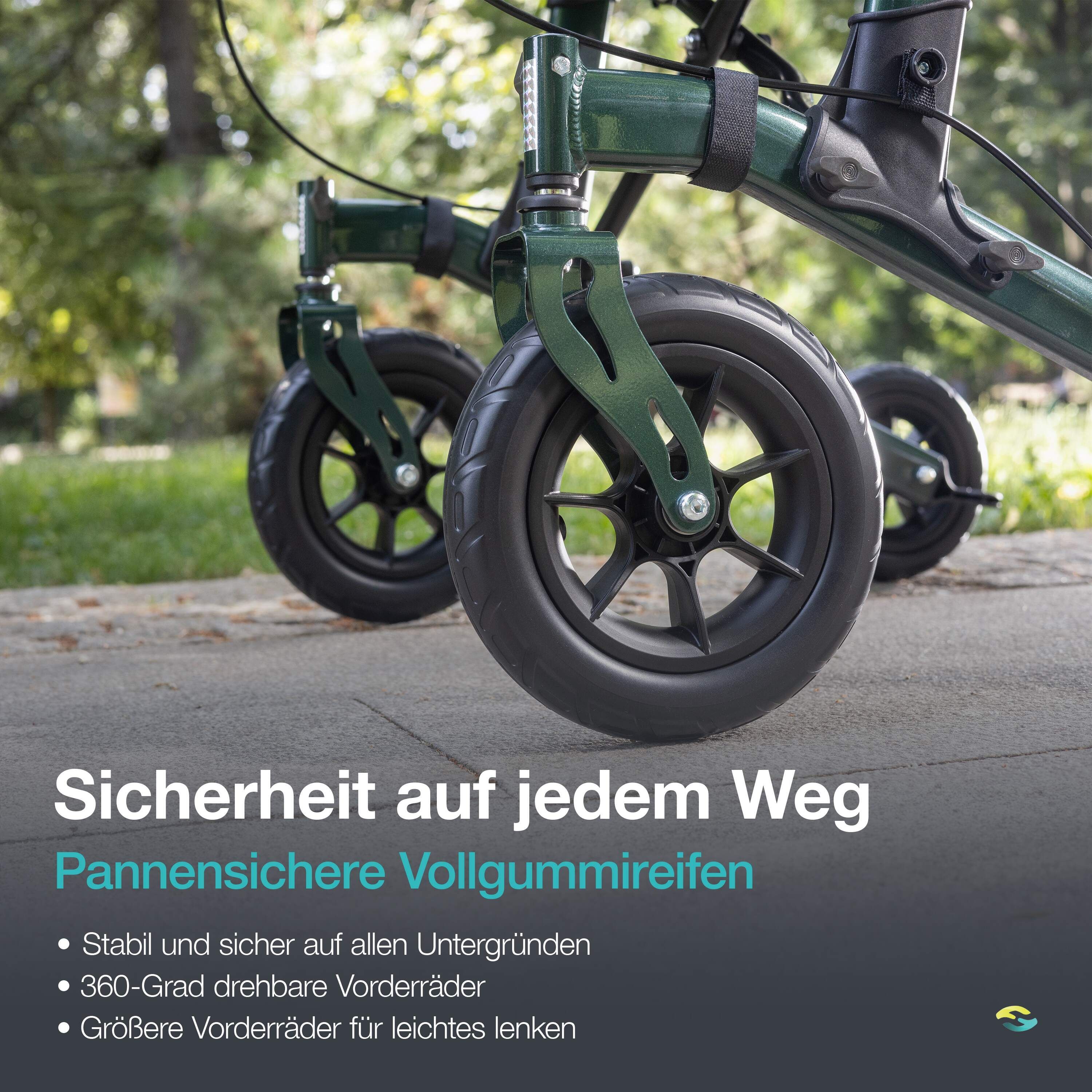 Nahaufnahme der Räder eines grünen Rollators auf einem Gehweg. Pannensichere Vollgummireifen.