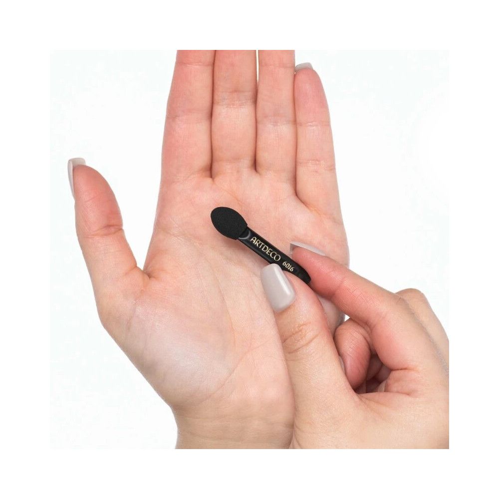 Applikator aus synthetischem Schaumstoff, schwarz, in einer Hand gehalten. Auf dem Griff steht ARTDECO 6016.