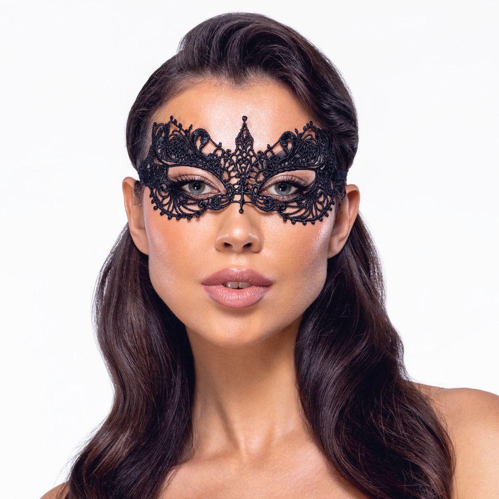 Schwarze Augenmaske aus Spitze, getragen von einer Frau. Die Maske bedeckt die Augenpartie und ist mit Verzierungen versehen.
