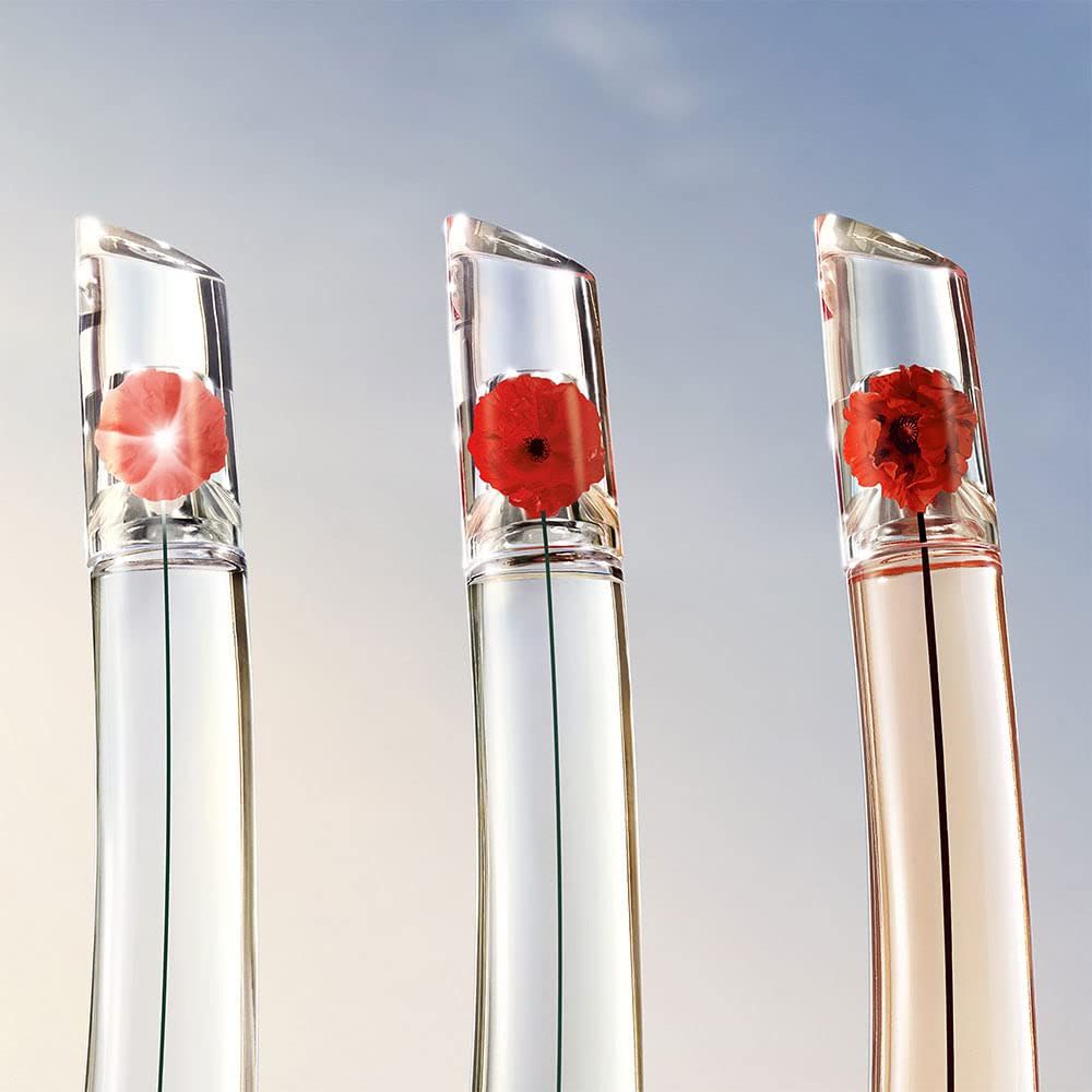 Drei Flakons mit Blumen im Deckel. Unterschiedliche Flüssigkeitsfarben.