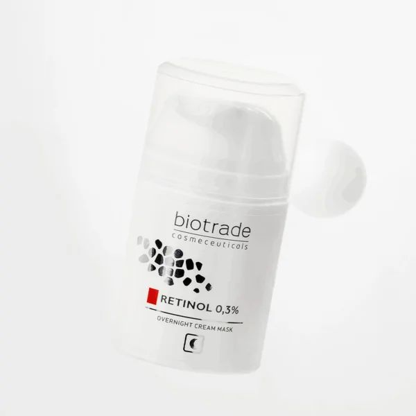 Weiße Flasche mit Aufschrift Biotrade, Retinol 0,3% und Nachtcreme-Gesichtsmaske. Flasche schwebt.