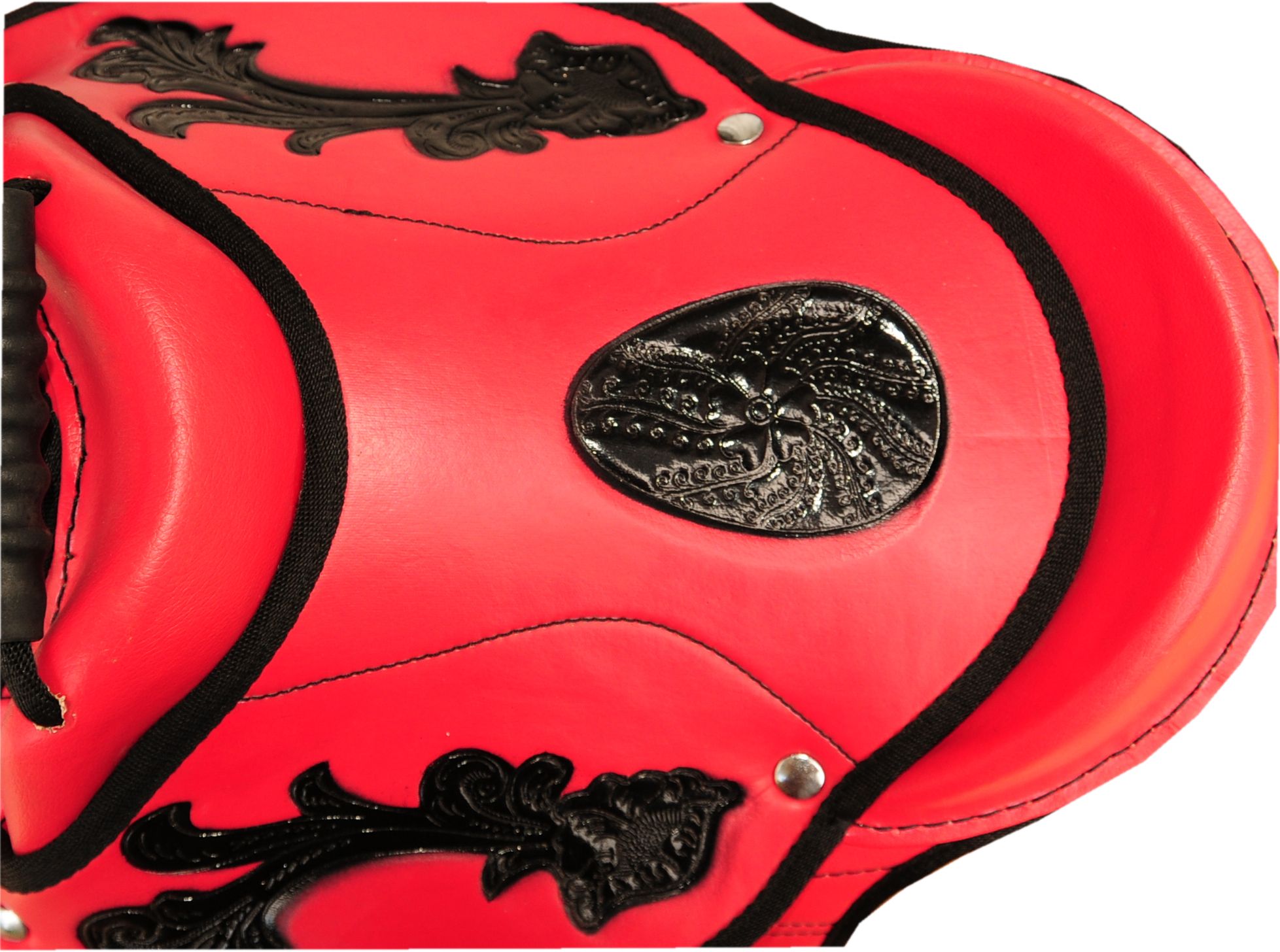 Rotes Reitkissen mit schwarzen Zierdetails. Schwarze Zierleisten und Verzierungen. Detailansicht.