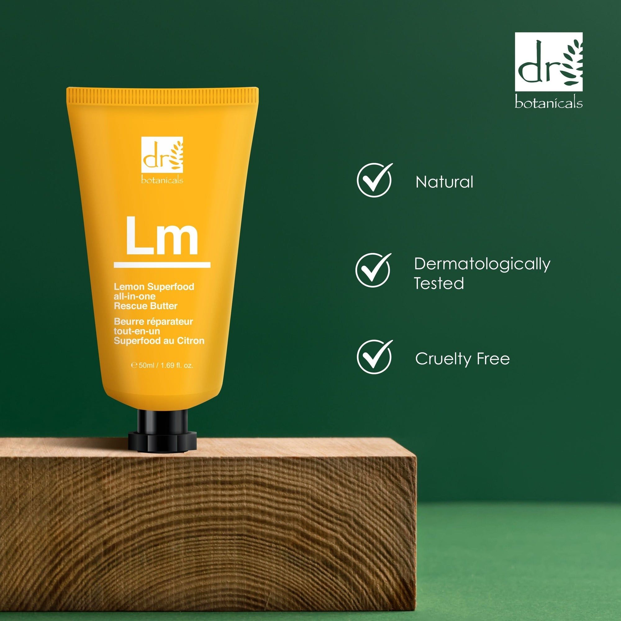 Gelbe Tube auf Holzblock. Aufschrift: Dr Botanicals, Lm Rescue Butter, Lemon Superfood. Logos: Natural, Dermatologically Tested, Cruelty Free.