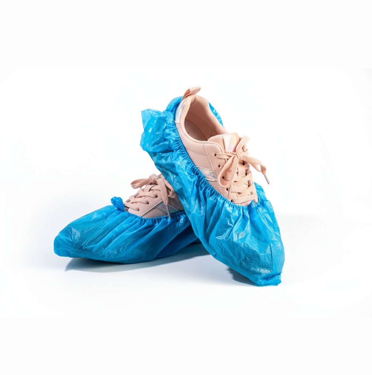 Blaue Überschuhe über Schuhen. Die Überschuhe sind aus einem glänzenden Material.