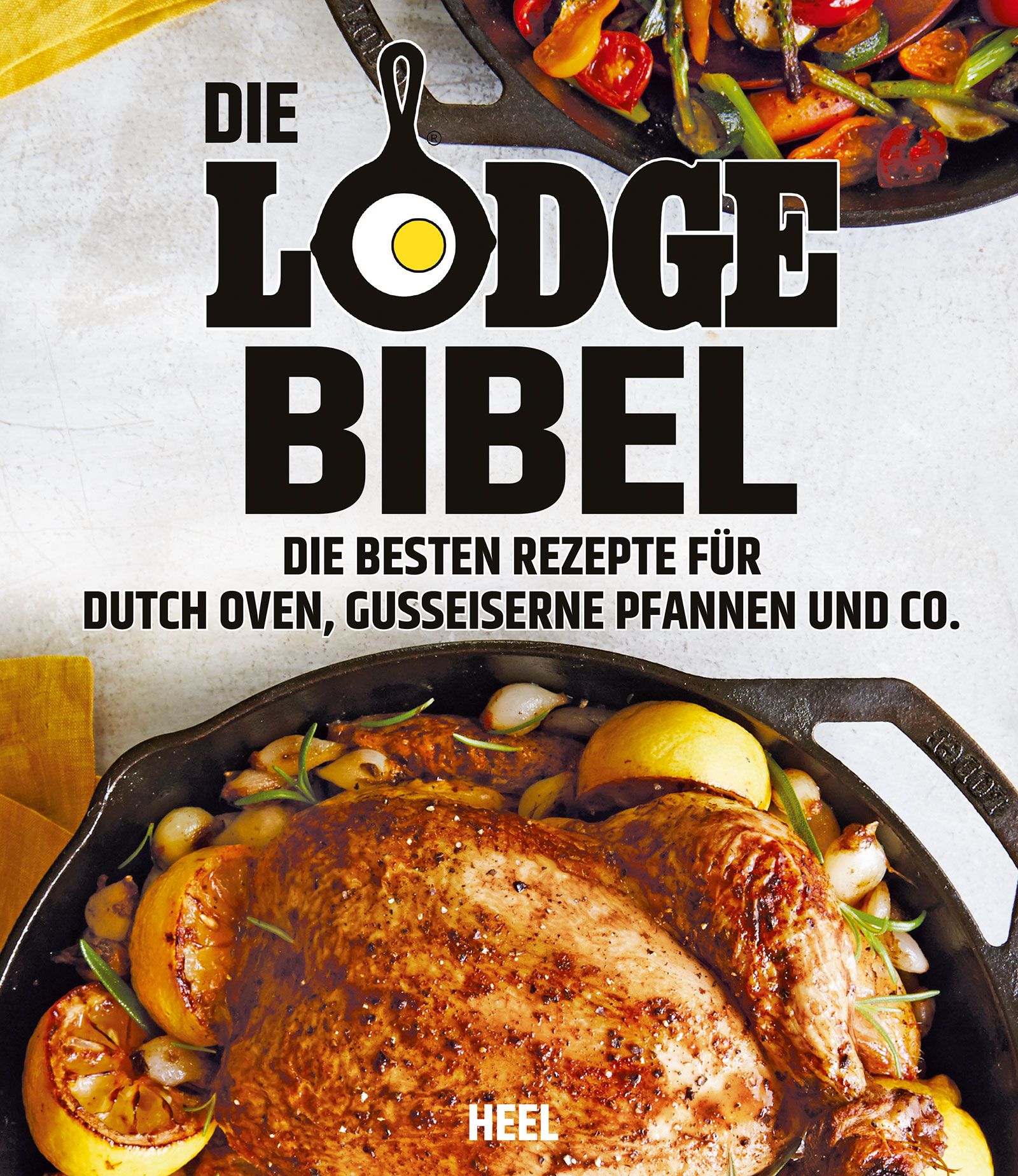 Buchcover: "Die Lodge Bibel". Titel in Schwarz, Kochutensilien-Illustration. Untertitel: Rezepte für Dutch Oven und Pfannen. Gebratenes Huhn in Pfanne.