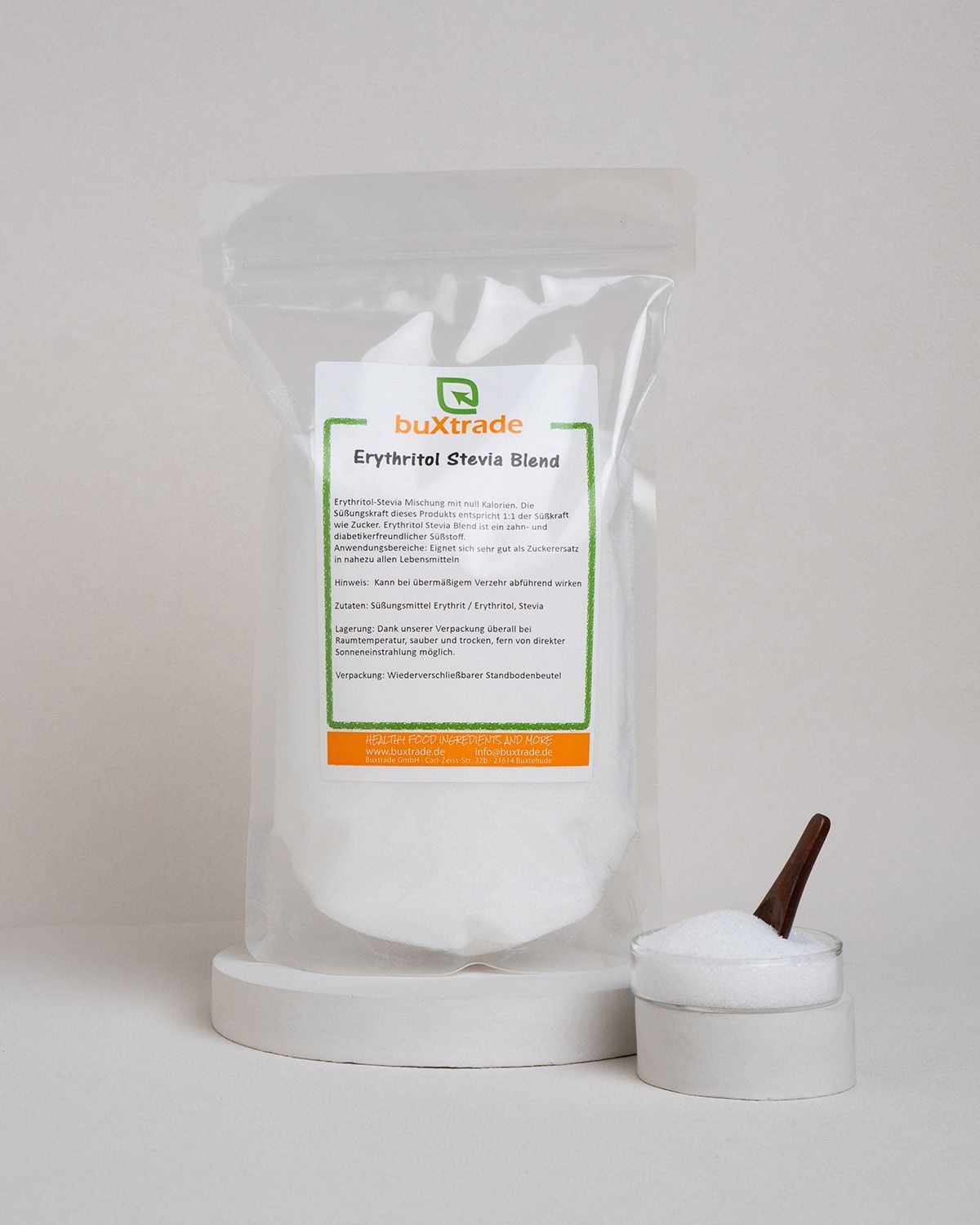 Transparente Verpackung mit weißem Pulver. Aufdruck: buXtrade Erythritol Stevia Blend. Holzlöffel und Schale daneben.