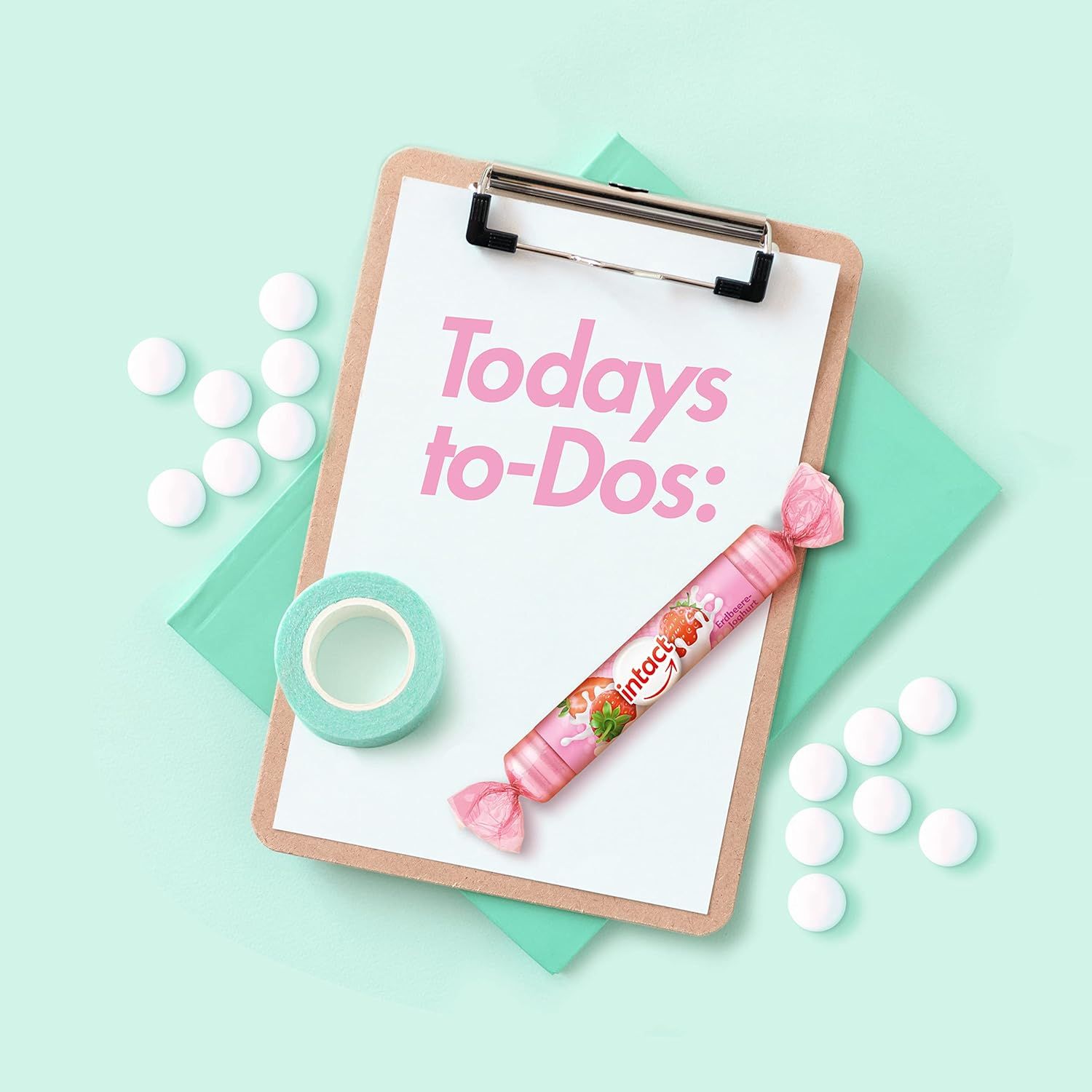 Ein Erdbeer-Joghurt Traubenzucker Rolle neben Notizblock, Klebeband und Tabletten. Text: Todays to-Dos: