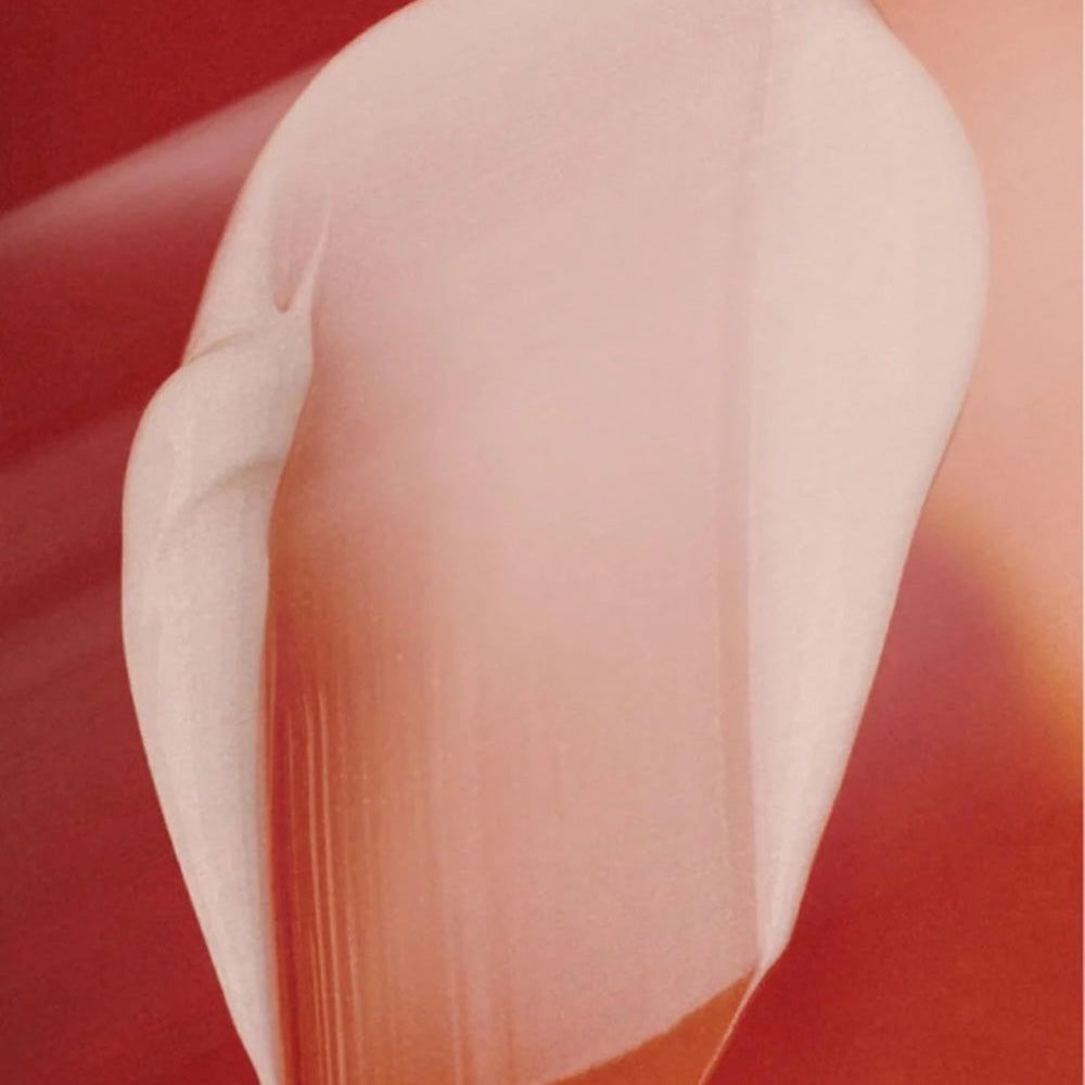 Nahaufnahme einer Creme. Rosa und weiß, glatte Textur. Auf rotem Hintergrund.