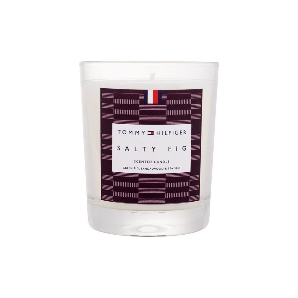 Duftkerze in Glasbehälter. Aufkleber mit Tommy Hilfiger Logo, Text: Salty Fig, Scented Candle. Grünfeige, Sandelholz & Meersalz.