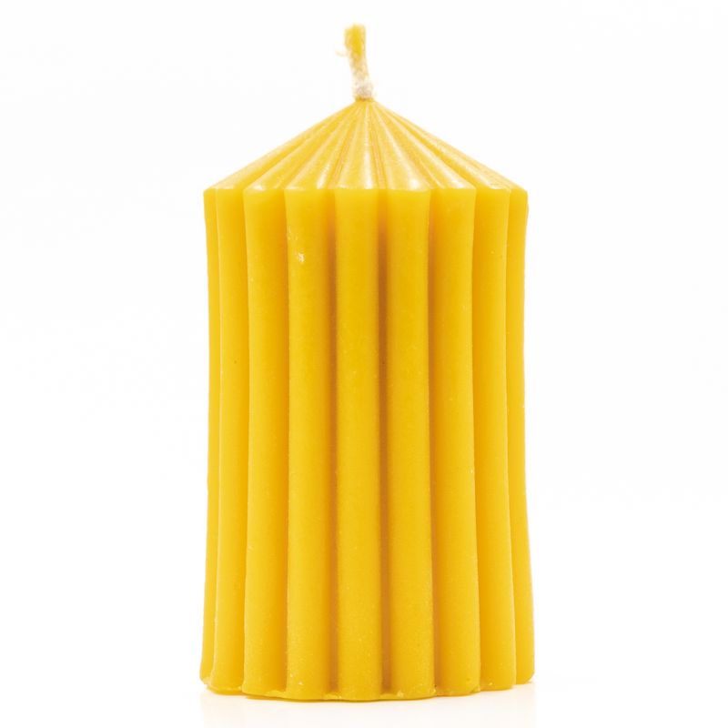 Gelbe Wachskerze mit geriffelter Oberfläche. Zylindrische Form mit spitz zulaufendem oberen Ende. Docht sichtbar.