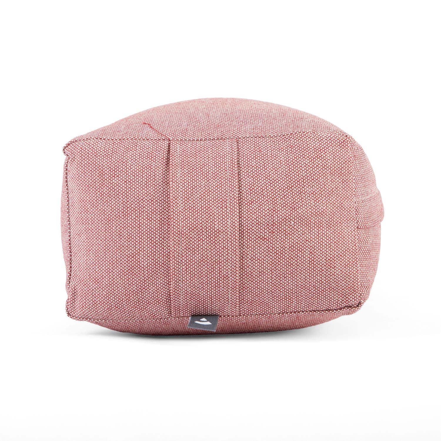 Ein rosafarbener Yoga-Bolster, von vorne gesehen, mit sichtbaren Nähten und einem kleinen Logo.
