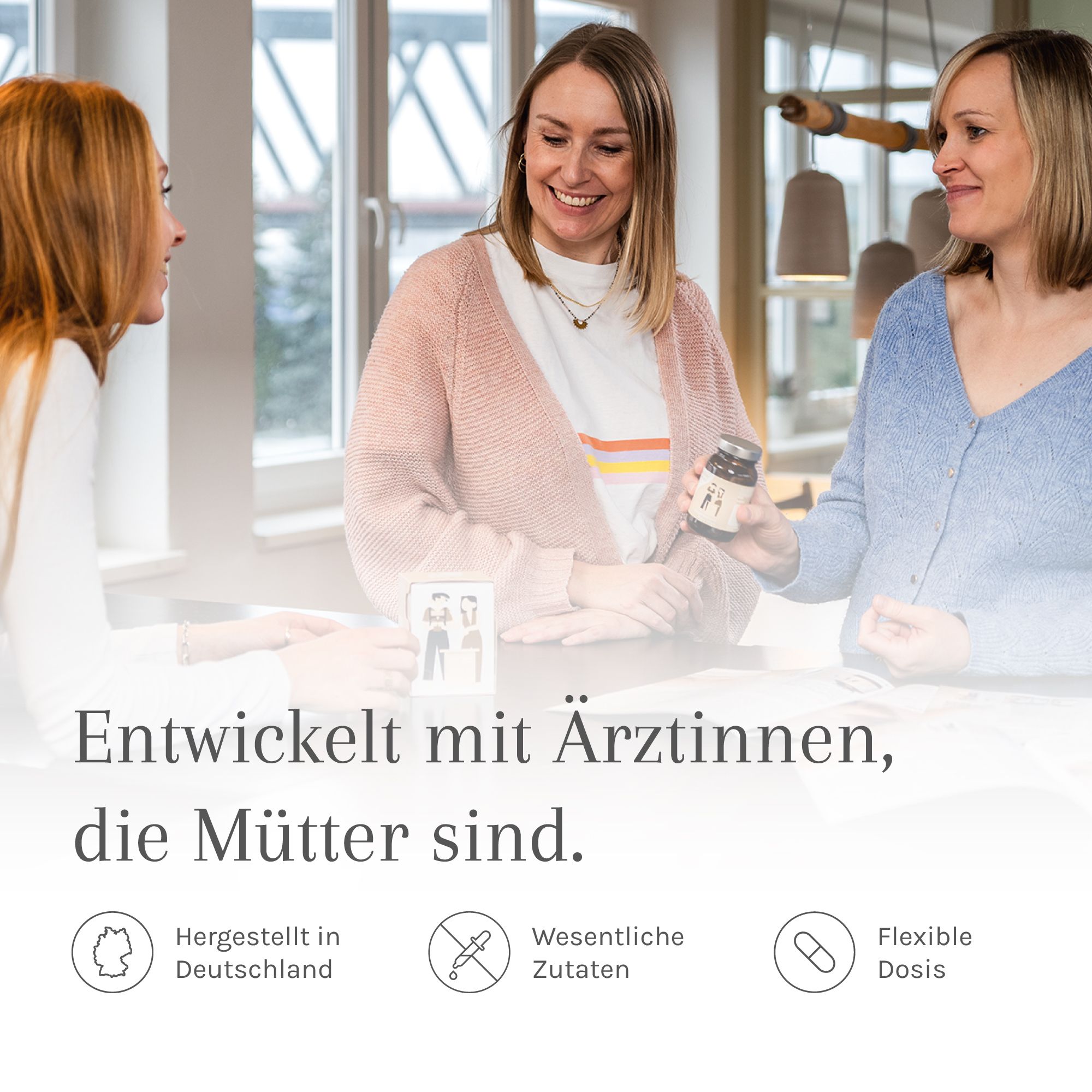 Drei Frauen unterhalten sich. Flasche mit Etikett. Text: Entwickelt mit Ärztinnen, die Mütter sind. Logos.