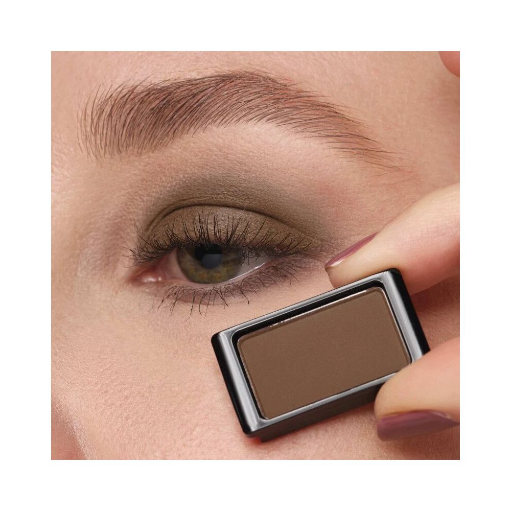 Artdeco Lidschatten Matt 520 Light Grey Mocha. Brauner Lidschatten in schwarzem Behälter. Gehalten vor einem Auge.