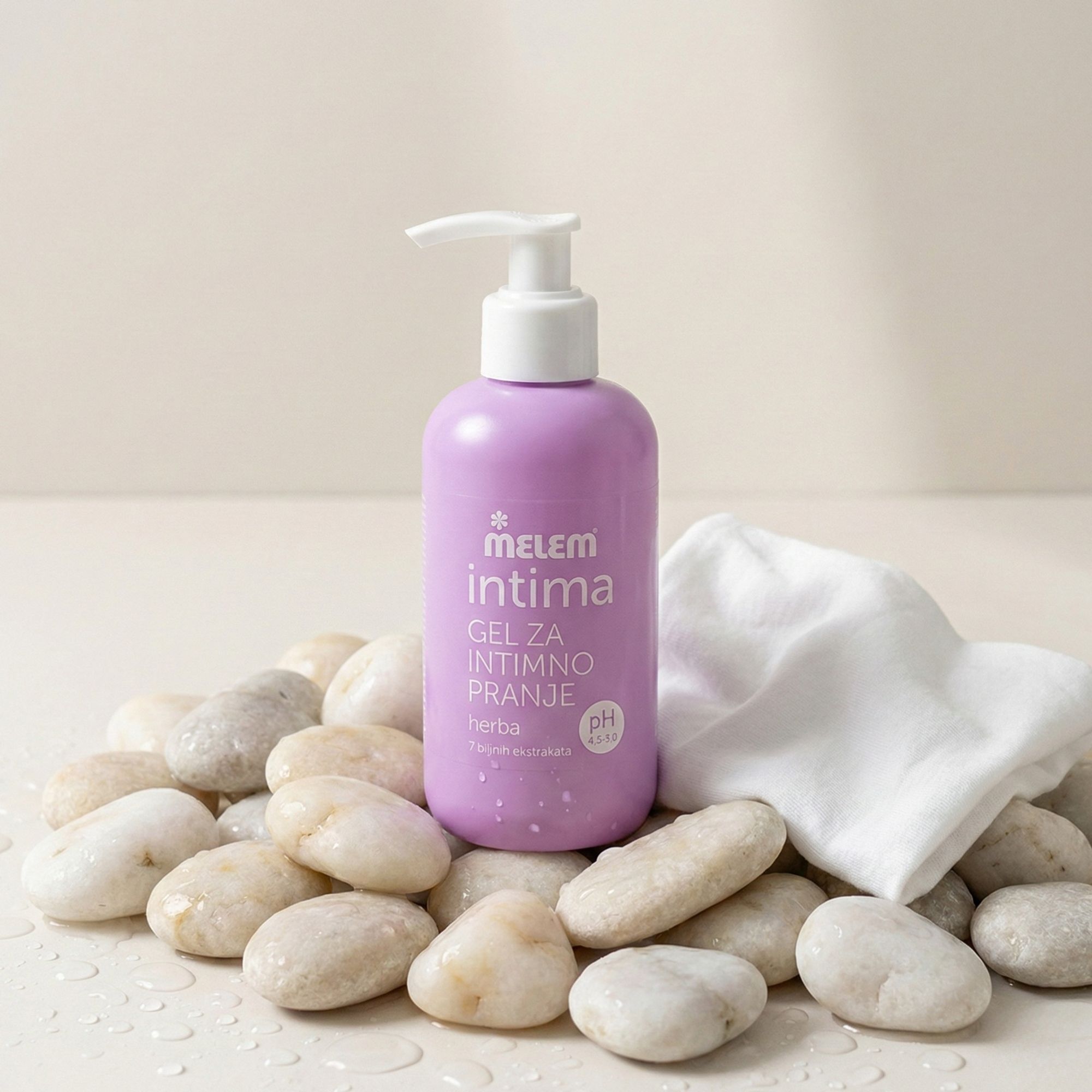 Lila Flasche Intim-Gel mit Pumpe, umgeben von Steinen und einem Tuch. Aufschrift: Melem intima, Gel za intimno pranje, herba, pH 4.5-5.0.