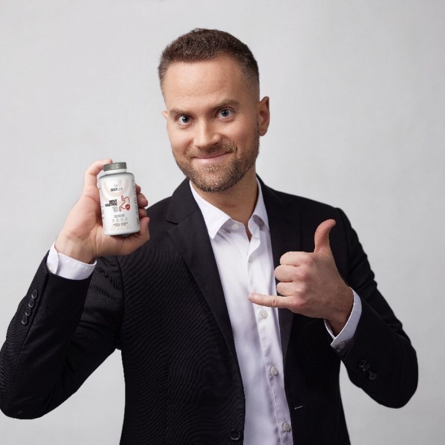 Mann hält eine weiße Flasche mit grauen Deckel. Aufschrift: BEST LAB BEST GASTRIC. Rotes Magen-Symbol. Mann zeigt Daumen hoch.