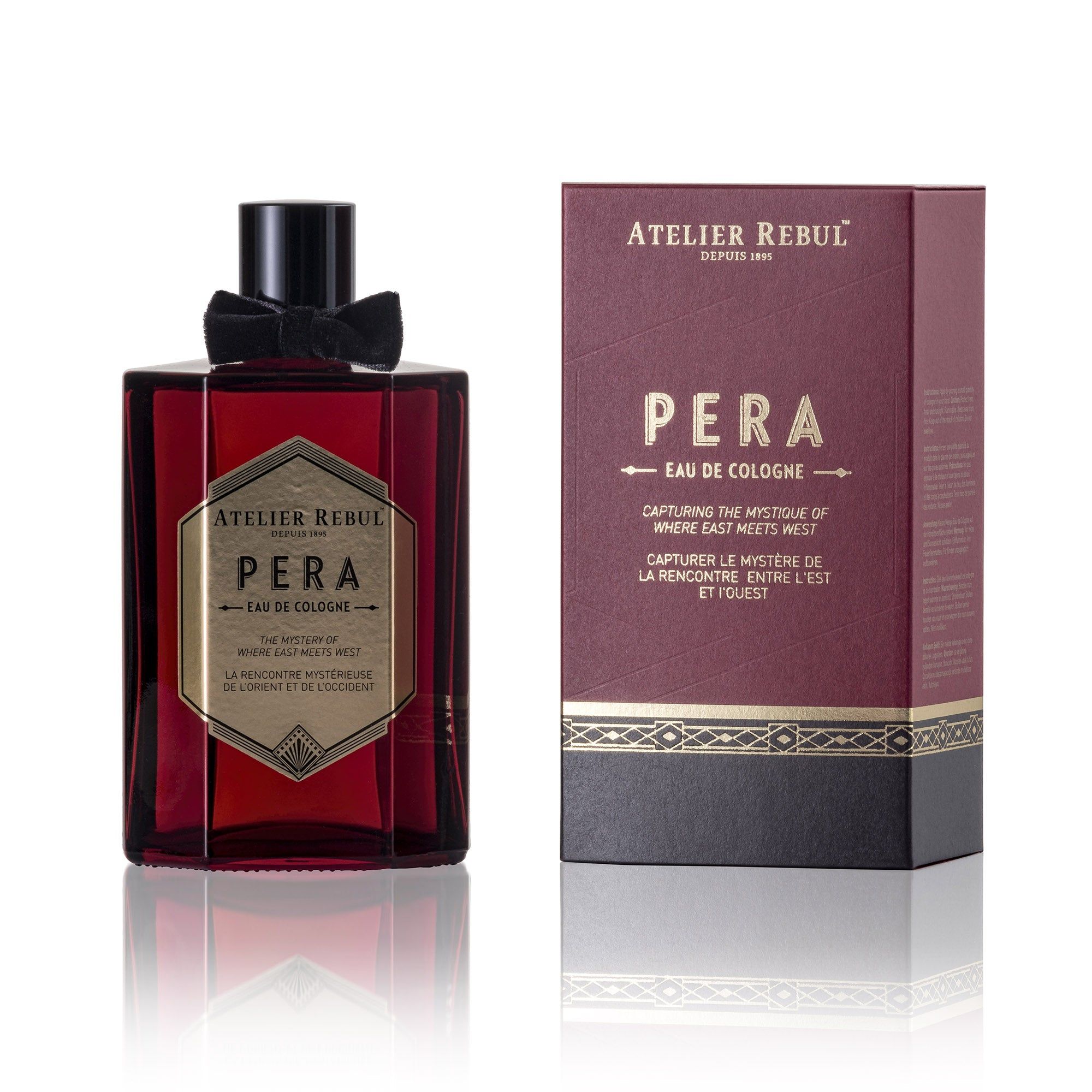 Rote Glasflasche und Verpackung. Aufschrift: Atelier Rebul Pera Eau de Cologne. Schwarzer Verschluss und Schleife.