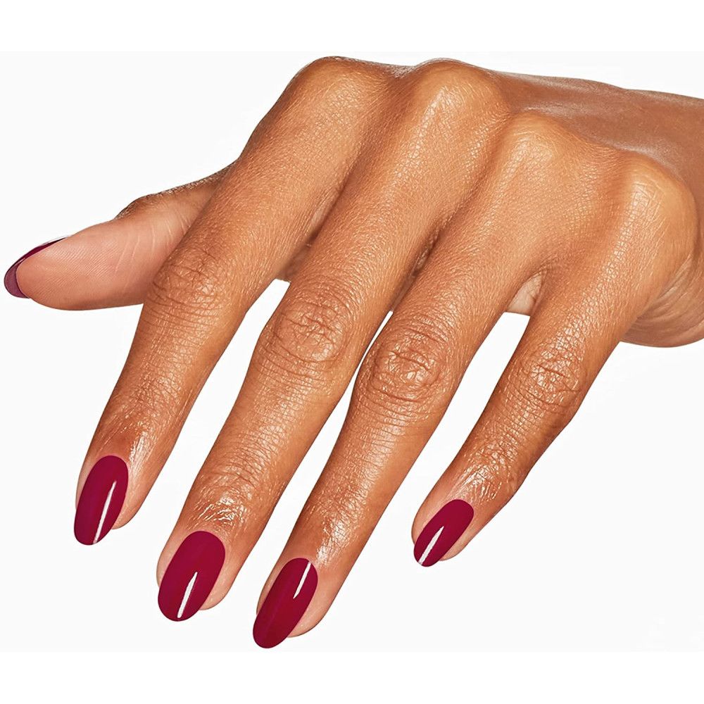 Hand mit lackierten Nägeln in tiefem Rot. Oval geformt. Hautton.