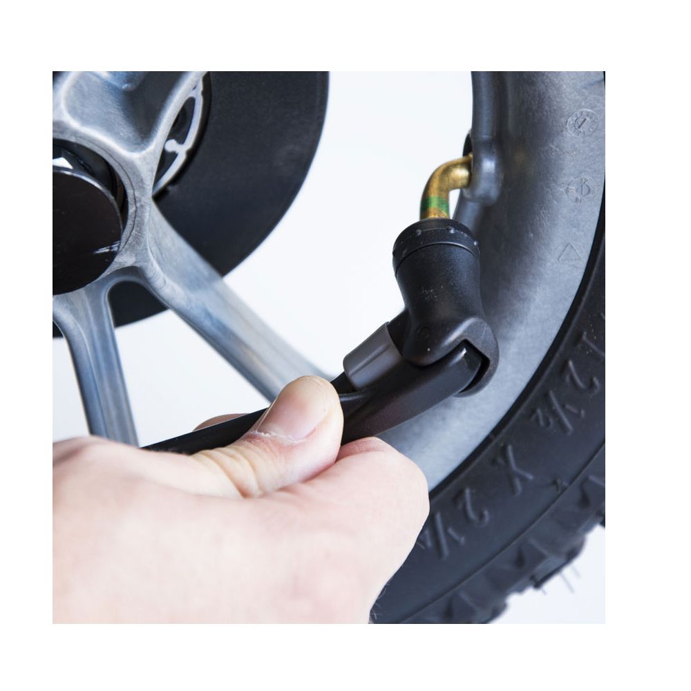 Nahaufnahme eines Reifens und eines Ventils. Schwarzer Schlauchanschluss. Goldfarbenes Ventil.