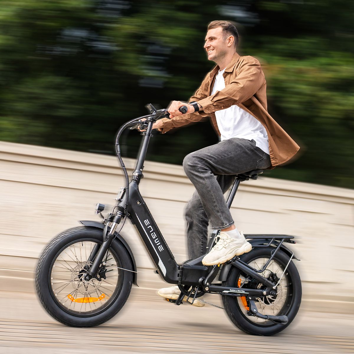 Mann fährt auf einem schwarzen Elektrofahrrad. Das ENGWE-Logo ist sichtbar. Der Hintergrund ist verschwommen.