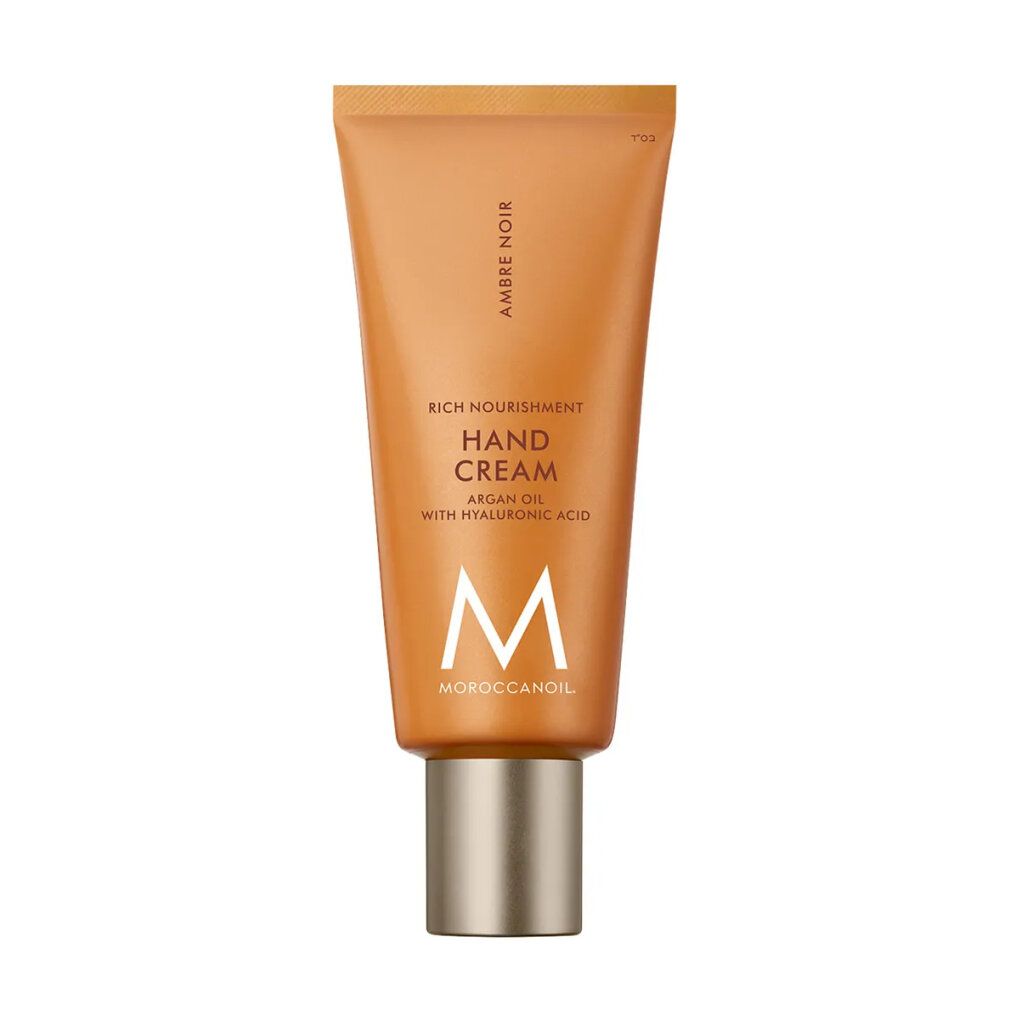Handcreme-Tube, bernsteinfarben. Text: Ambre Noir, Rich Nourishment Hand Cream, Argan Oil with Hyaluronic Acid. Logo: M, Moroccanoil.